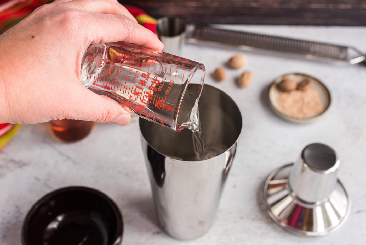 pouring creme de cacao into cocktail shaker
