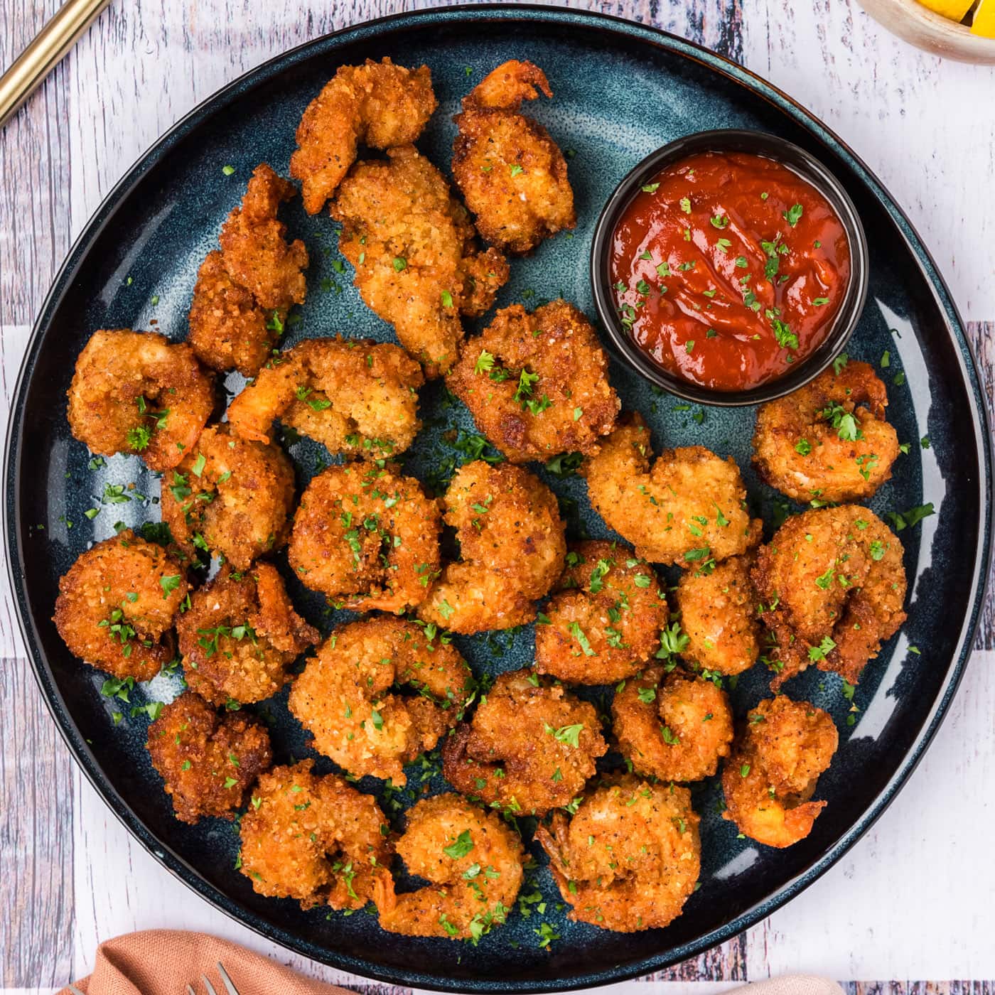 Breaded Shrimp on a plate with a bowl of cocktail sauce