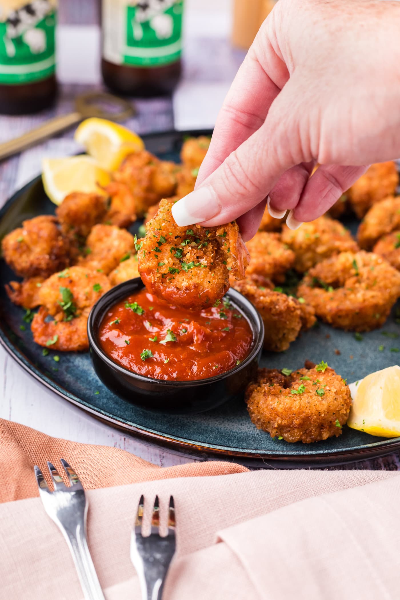 Breaded Shrimp being dipped in cocktail sauce