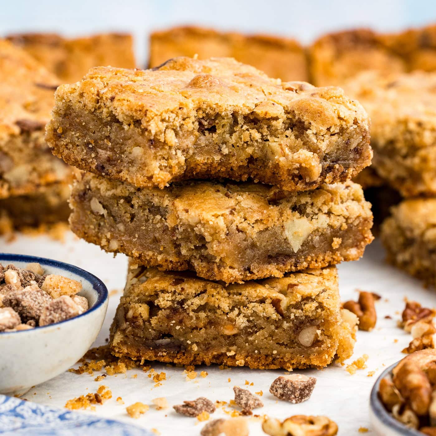 Close up photo of a stack of Brown Butter Chocolate Toffee Blondies with a bite taken out of the top one