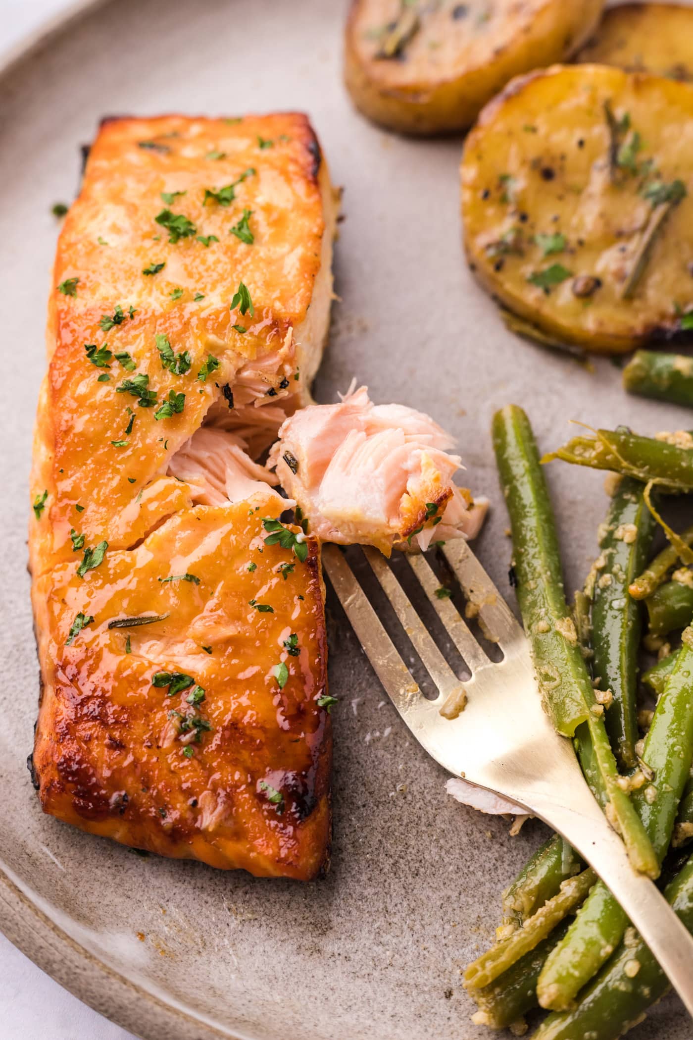 Piece of Brown Sugar Salmon on a fork next to the salmon filet