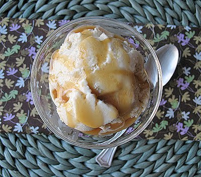 An overhead picture of brown sugar vanilla bean ice cream in a clear bowl with caramel drizzle on top.