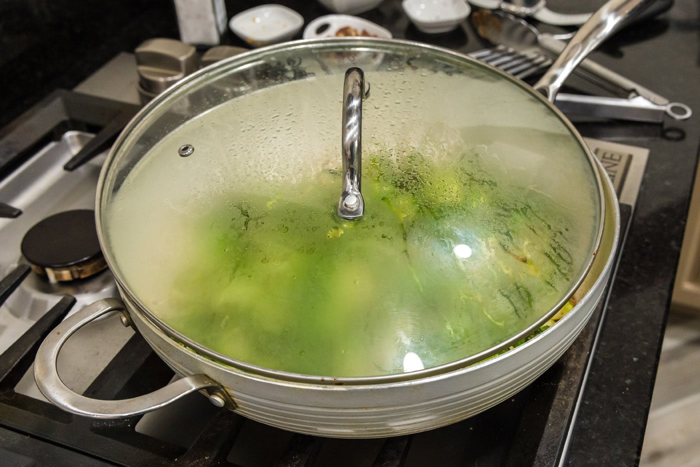 lid over the top of brussels sprouts in a skillet