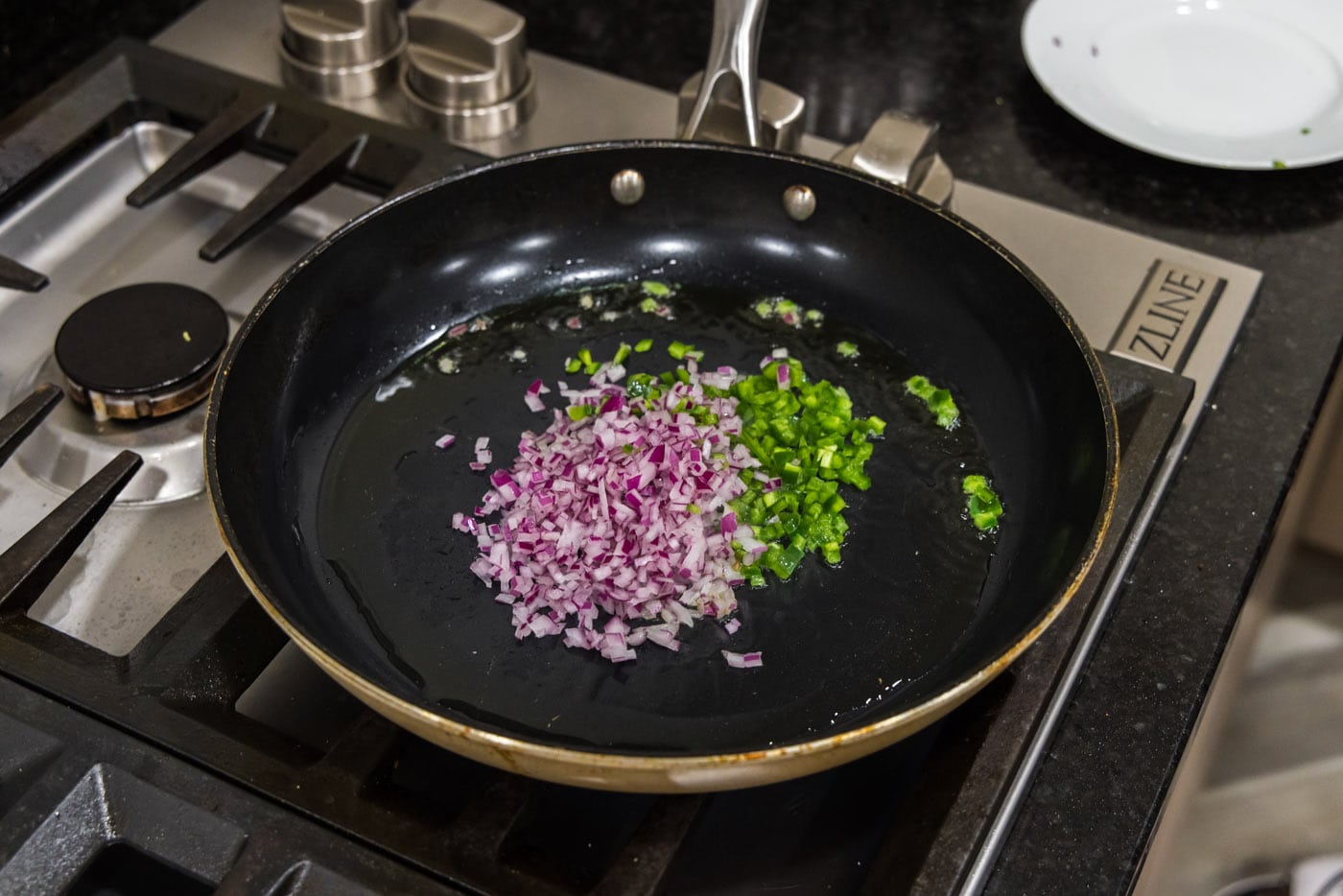 chopped onion and jalapeno peppers in a skillet with oil