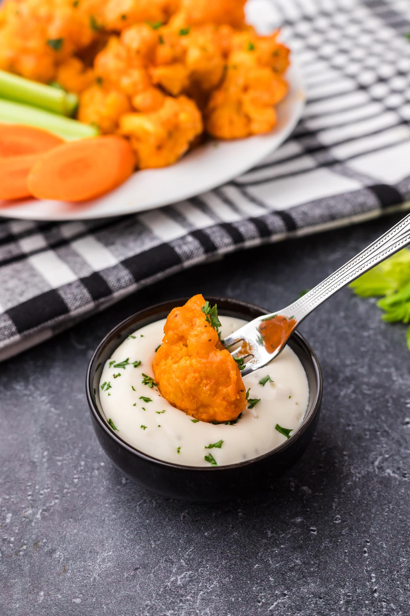 Buffalo Cauliflower being dipped into ranch