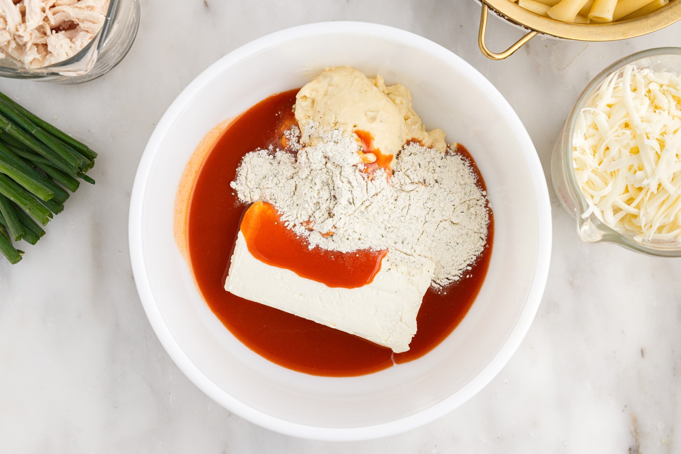 hot sauce, cream cheese, ranch seasoning mix, and cream f chicken soup in a bowl