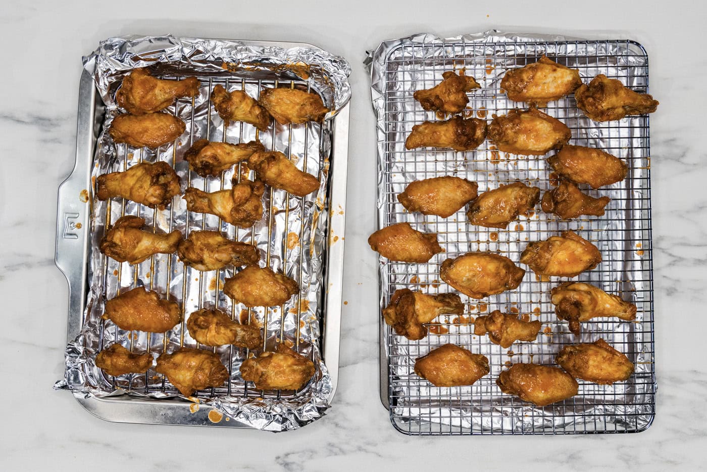 sauced chicken wings on a wire rack over a baking sheet
