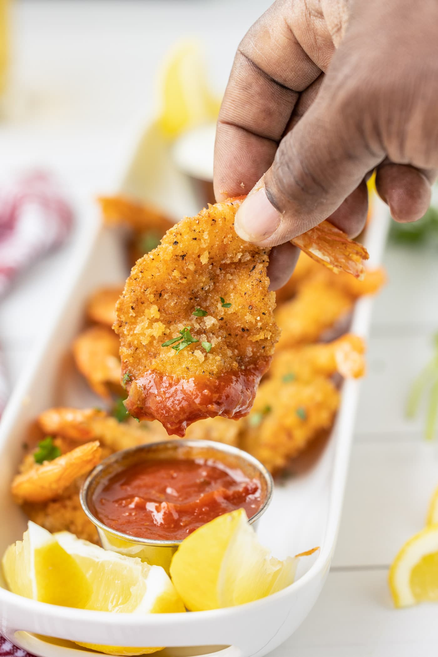 dipping a Butterfly Shrimp in cocktail sauce