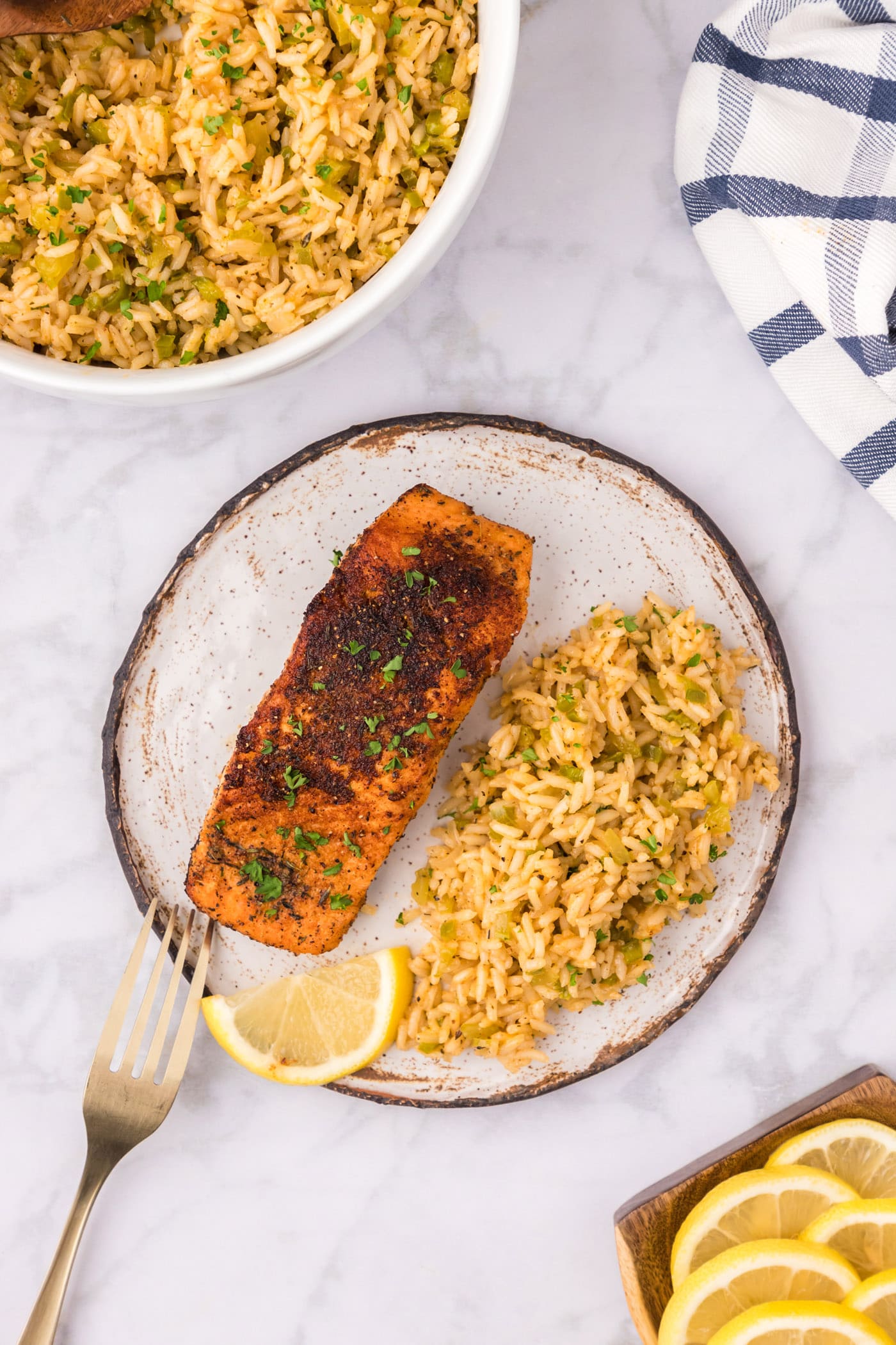 Cajun Salmon on a plate with cajun rice and a lemon slice