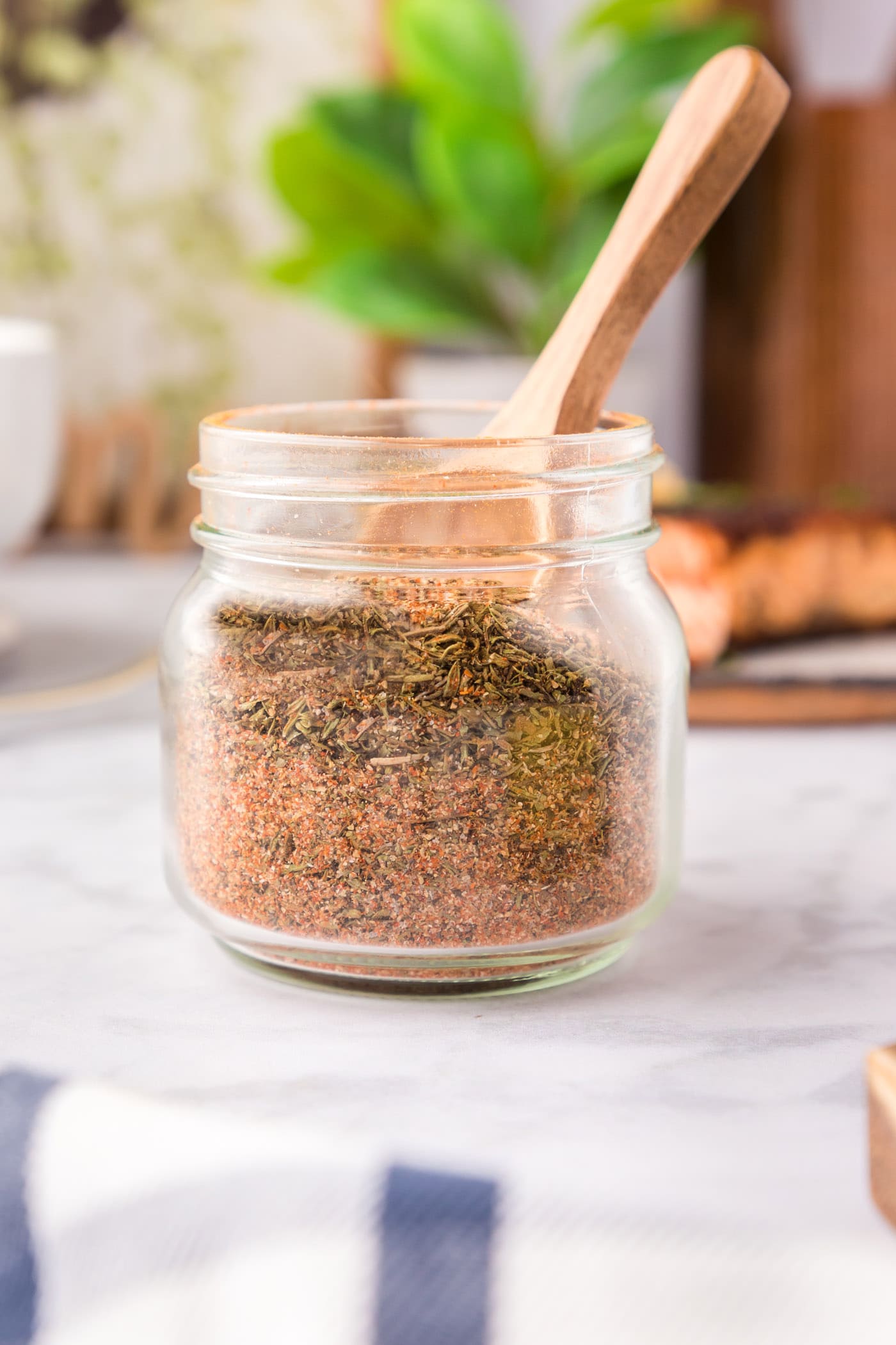 Jar of Cajun Seasoning with a wooden spoon in it