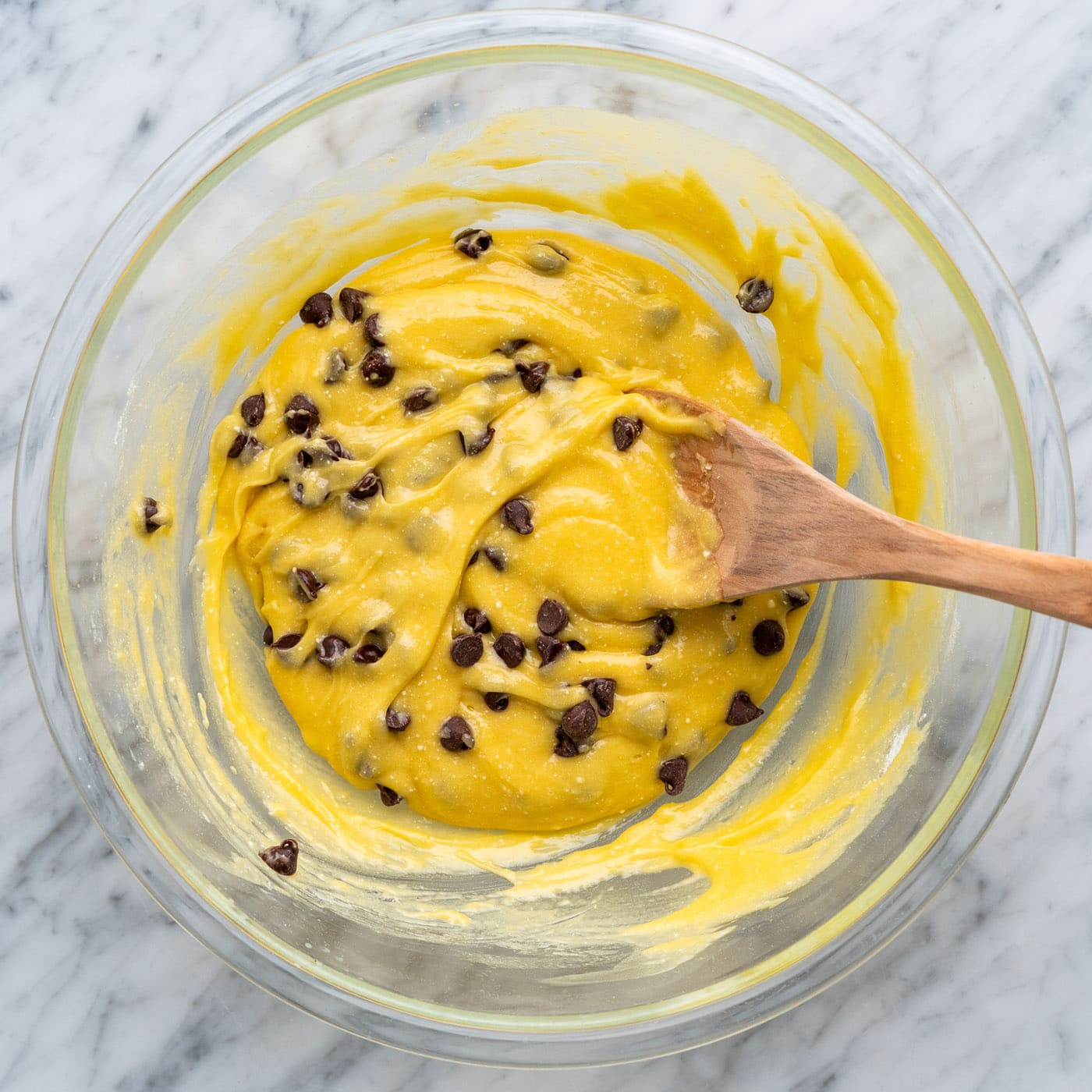 cake mix cookie bars mixed in a bowl with a wooden spoon