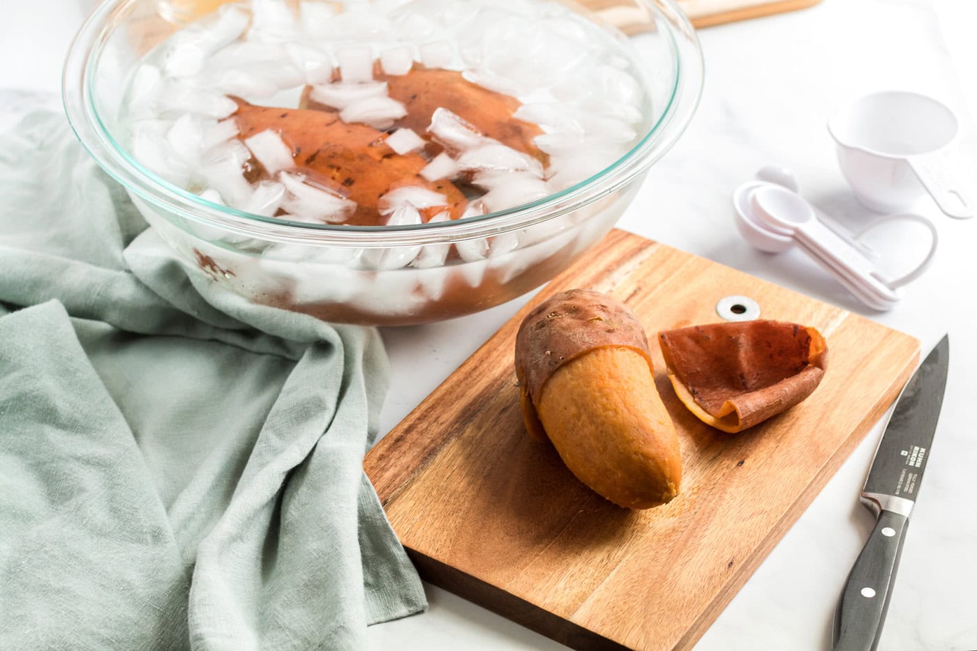 peeled sweet potato next to an ice bowl