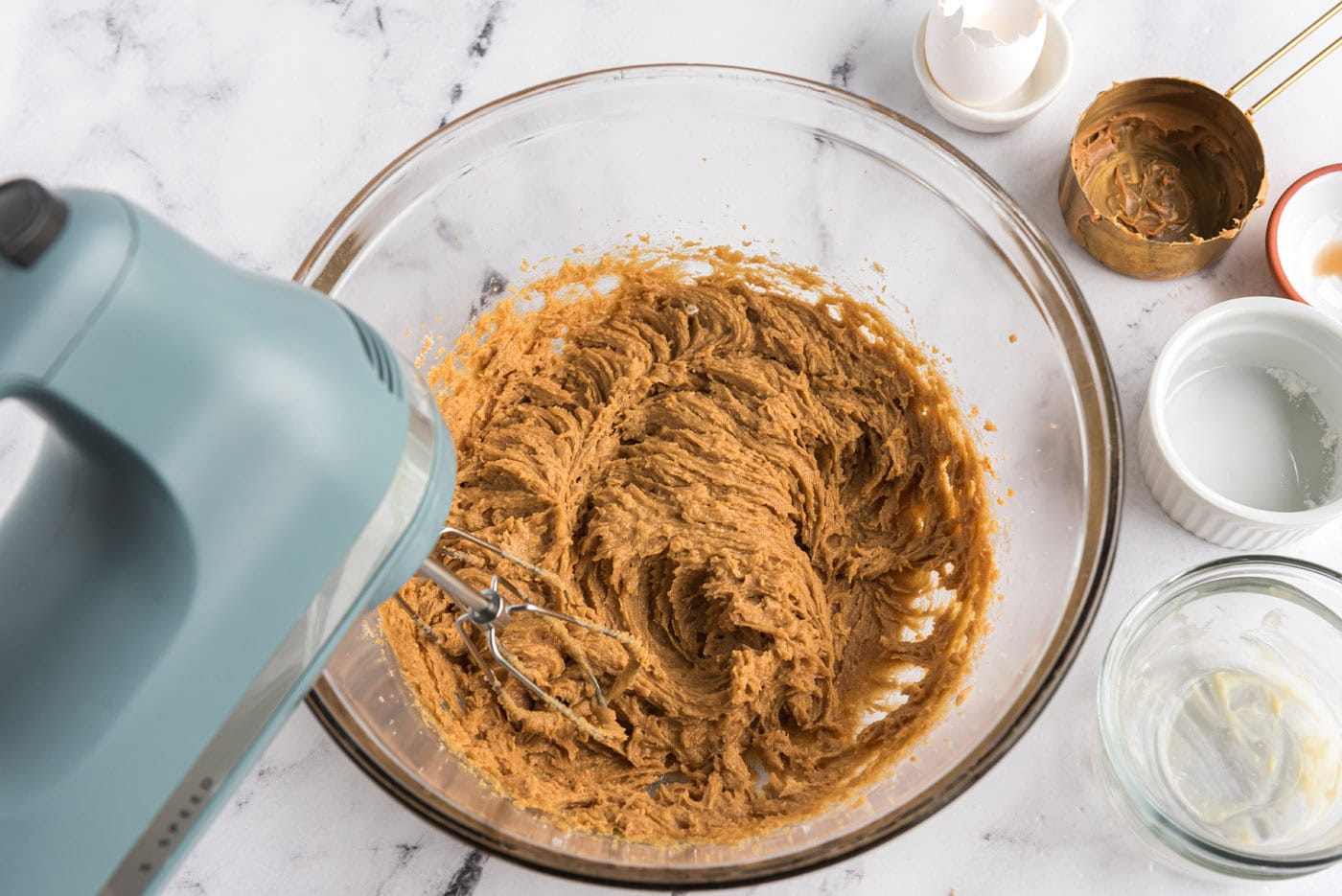 beating egg into peanut butter cookie dough in a bowl