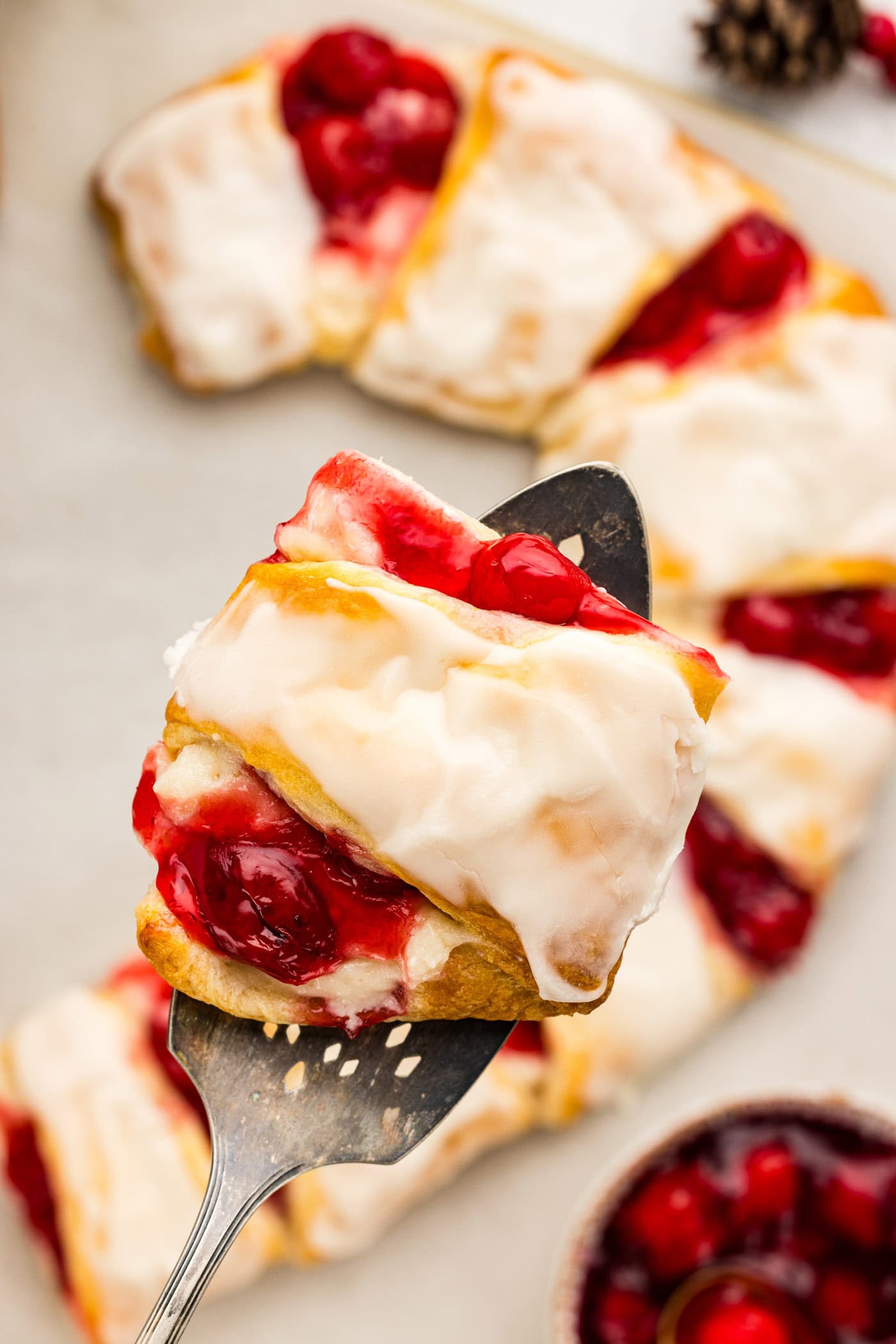 Slice of Candy Cane Danish held above the rest of the Candy Cane Danish