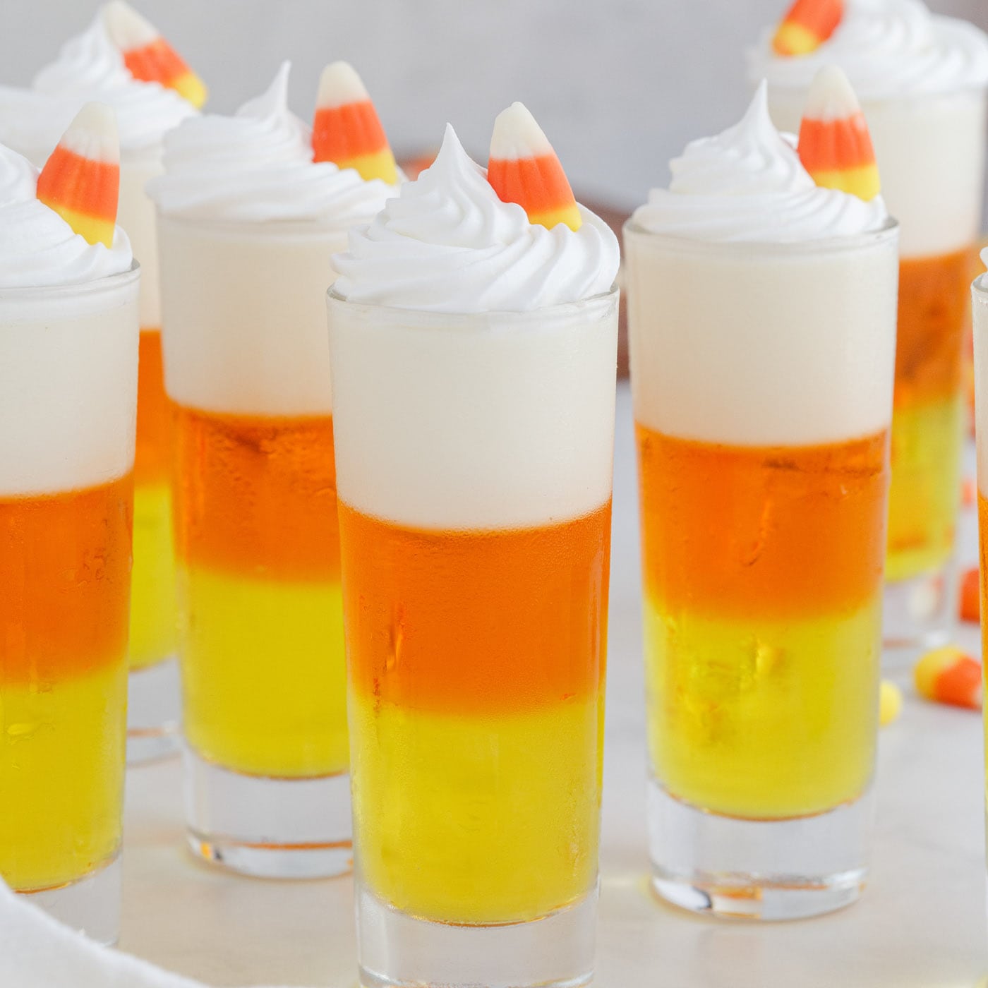 Candy Corn Jello Shots garnished with whip cream