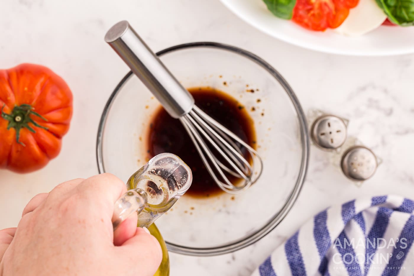 balsamic, pepper, olive oil, and salt in a bowl with whisk