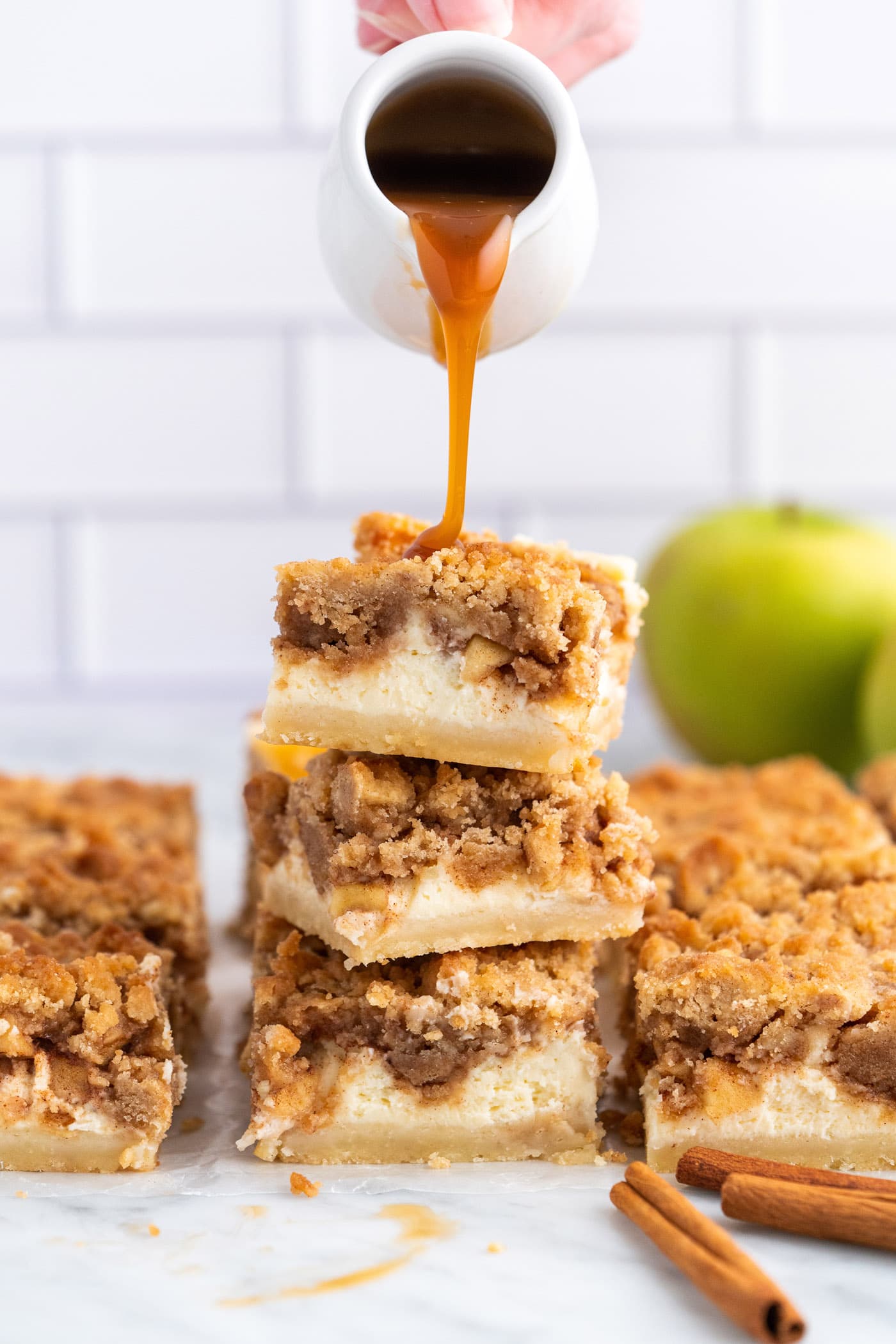 dripping caramel onto Caramel Apple Cheesecake Bars