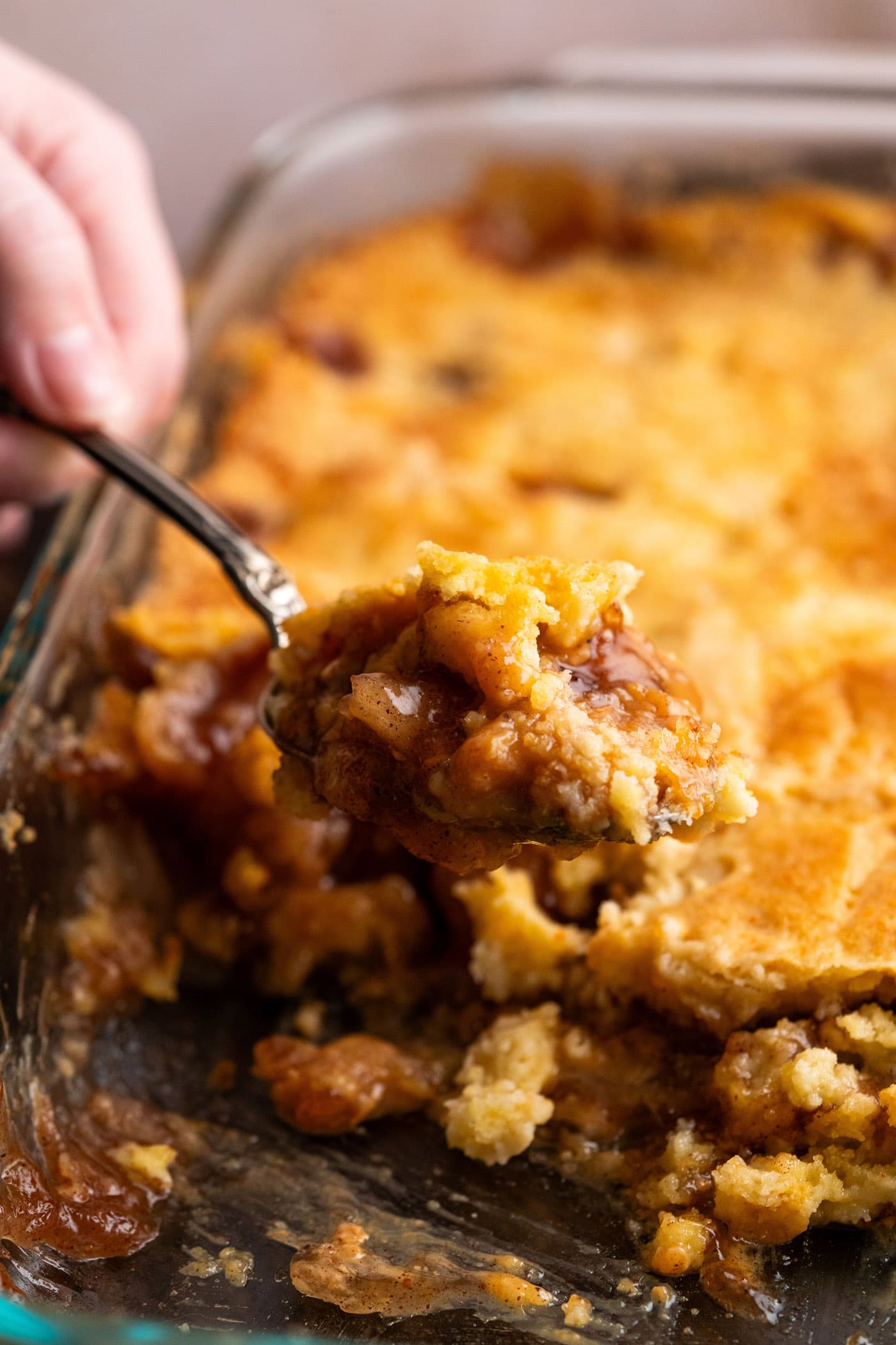 Scoop of Caramel Apple Dump Cake being lifted out of the pan