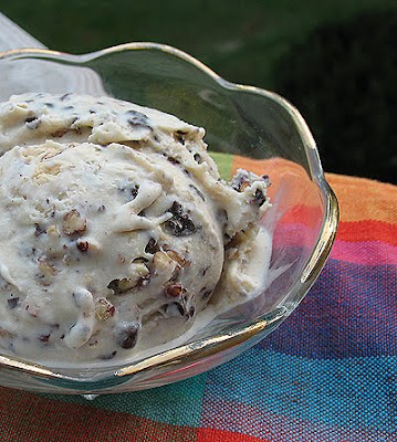 A close up photo of a bowl of caramel chocolate nut ice cream.