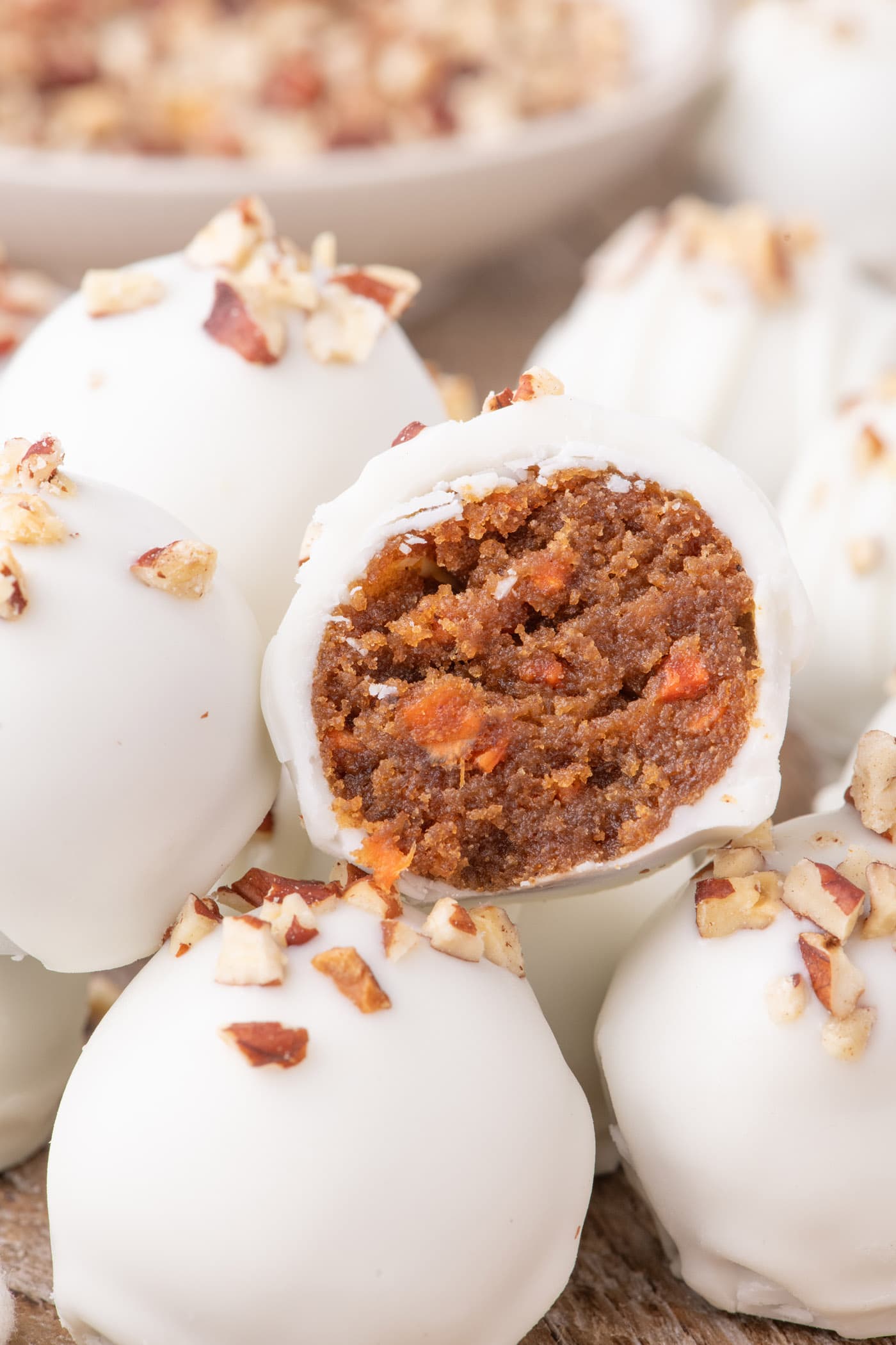 Close up photo of a Carrot Cake Truffle cut in half resting on more Carrot Cake Truffles