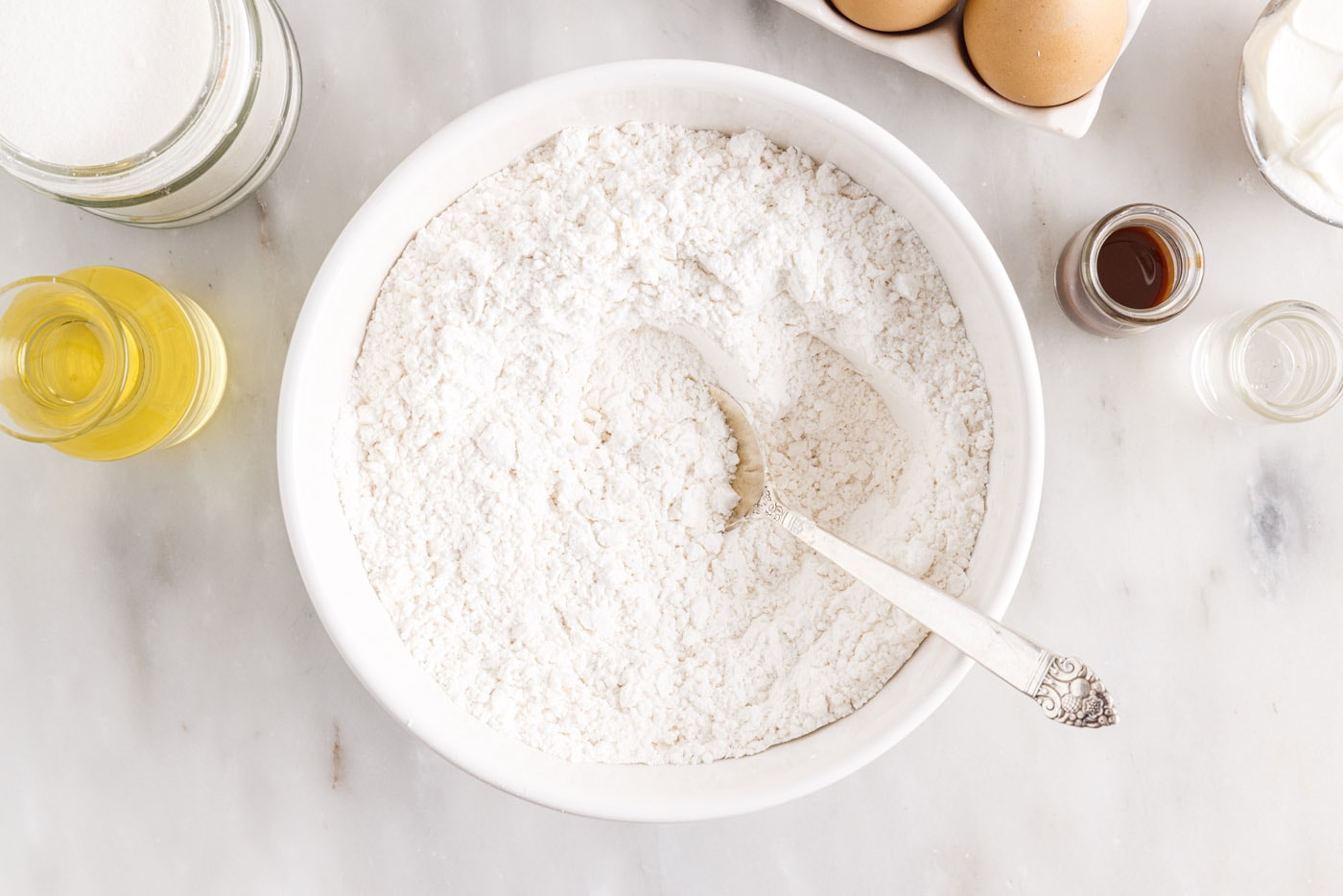 salt, baking powder, and baking soda mixed with flour in a bowl