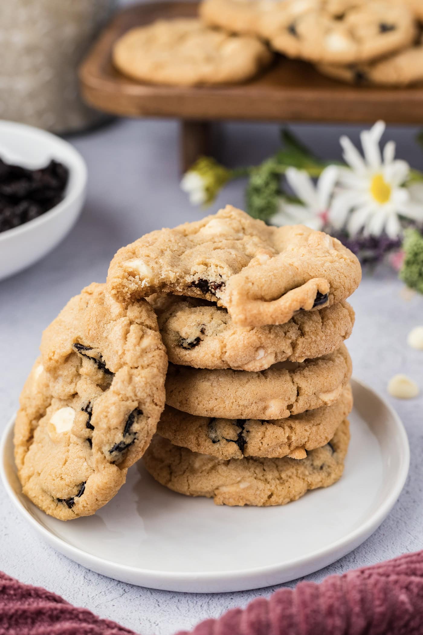 Stack of Cherry White Chocolate Chip Cookies with a bite taken out of the top cookie