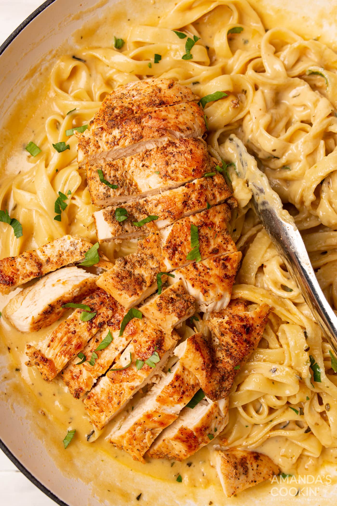 Chicken Alfredo with tongs