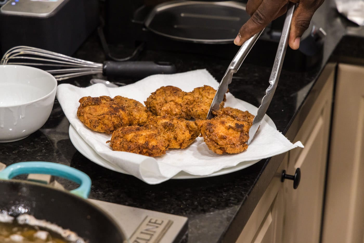 crispy fried boneless chicken highs on a paper towel lined plate