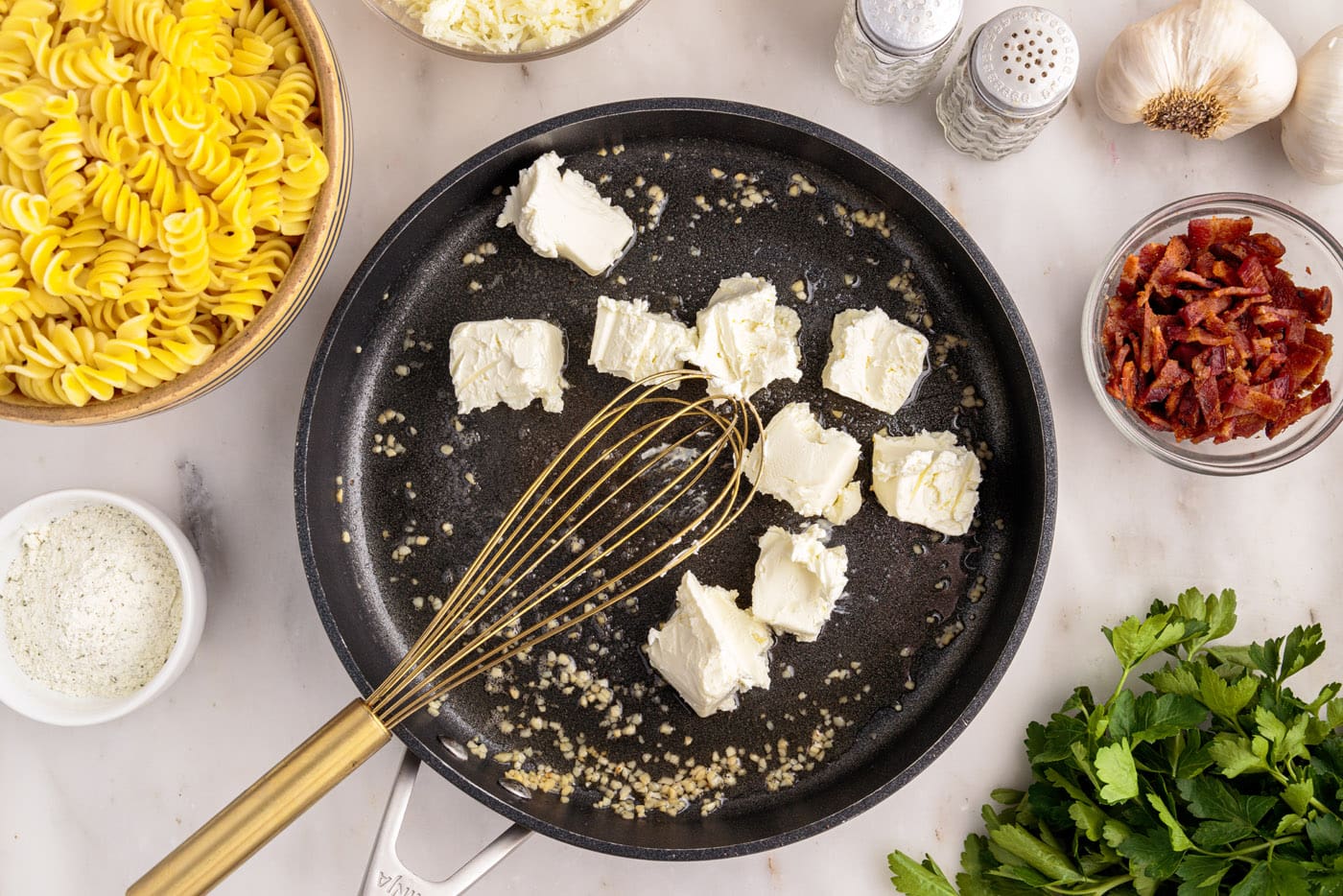 whisking cream cheese into skillet with garlic