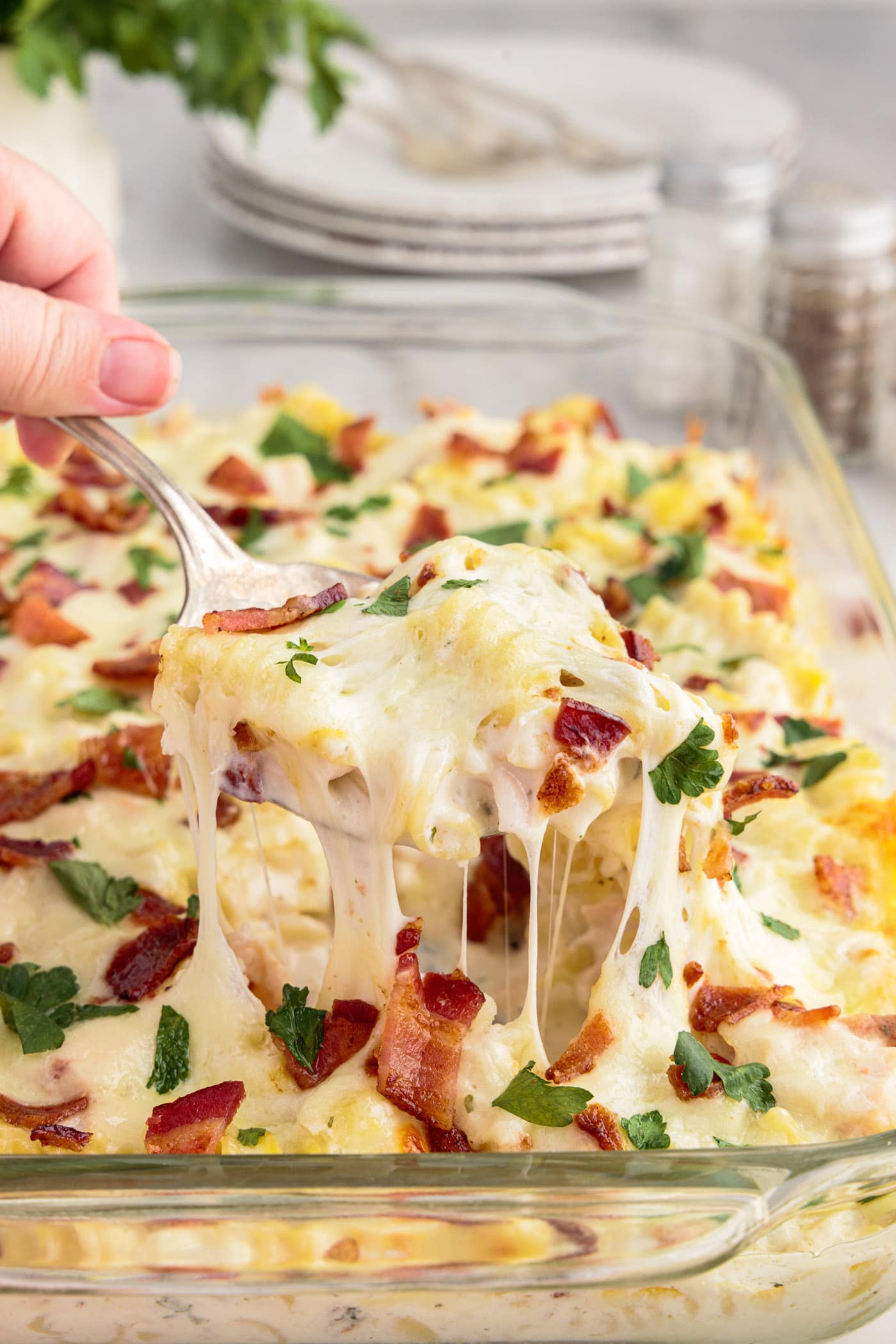 Spoonful of Chicken Bacon Ranch Casserole being lifted out of the casserole dish of Chicken Bacon Ranch Casserole