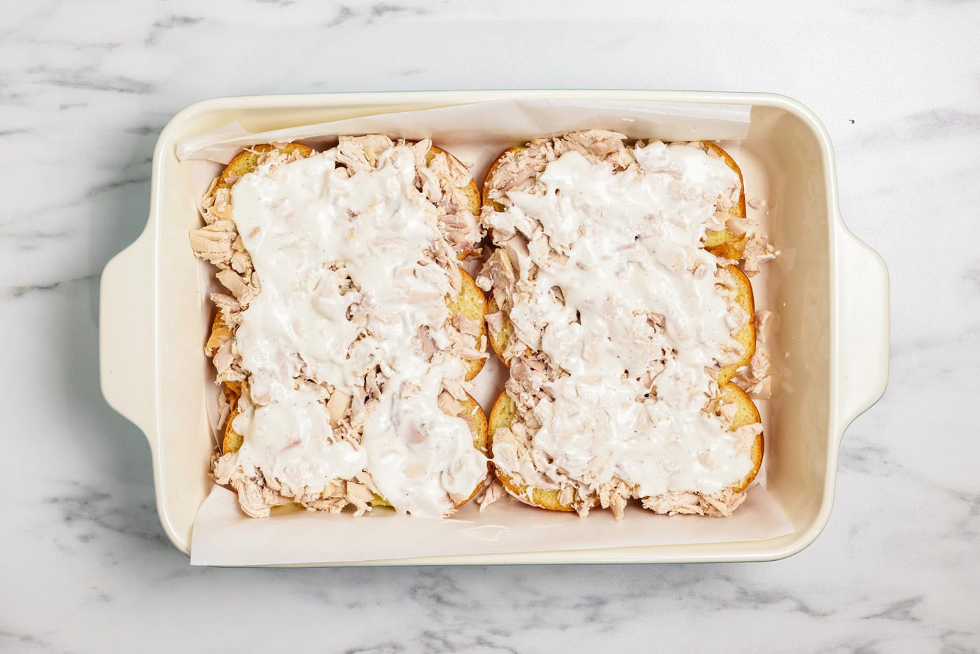 ranch dressing on top of slider buns in a baking dish