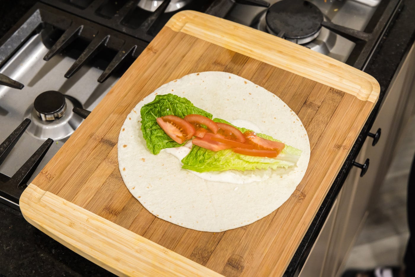 sliced tomato added on top of lettuce and ranch