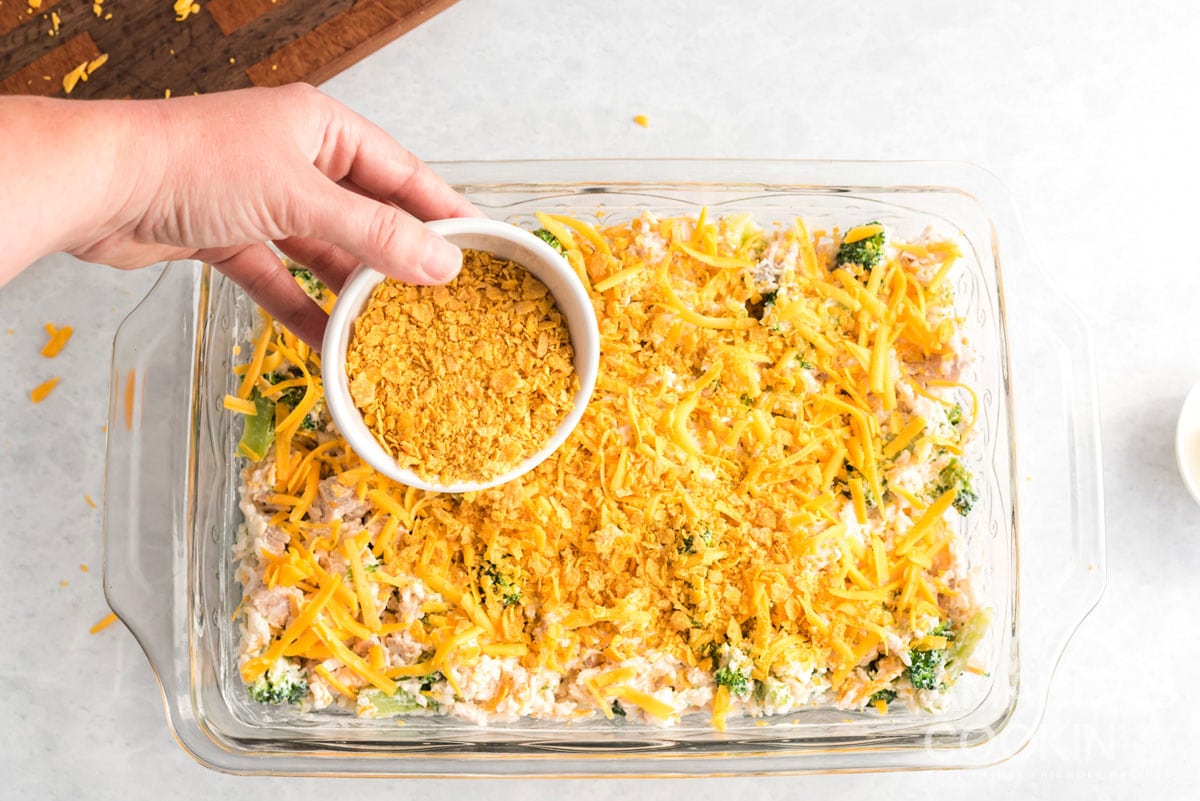 adding crushed corn flakes to Make Chicken Broccoli Rice Casserole