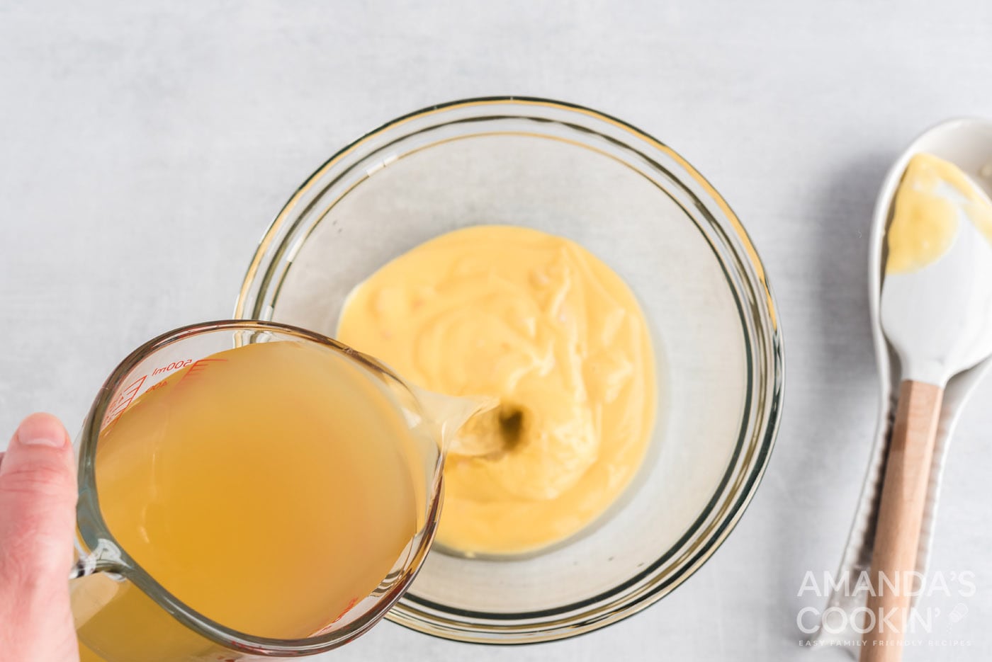 adding broth to mixing bowl