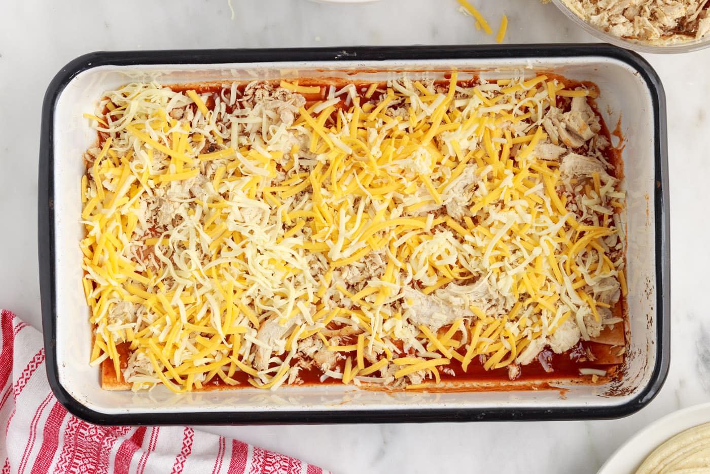 shredded cheese on top of chicken enchilada casserole