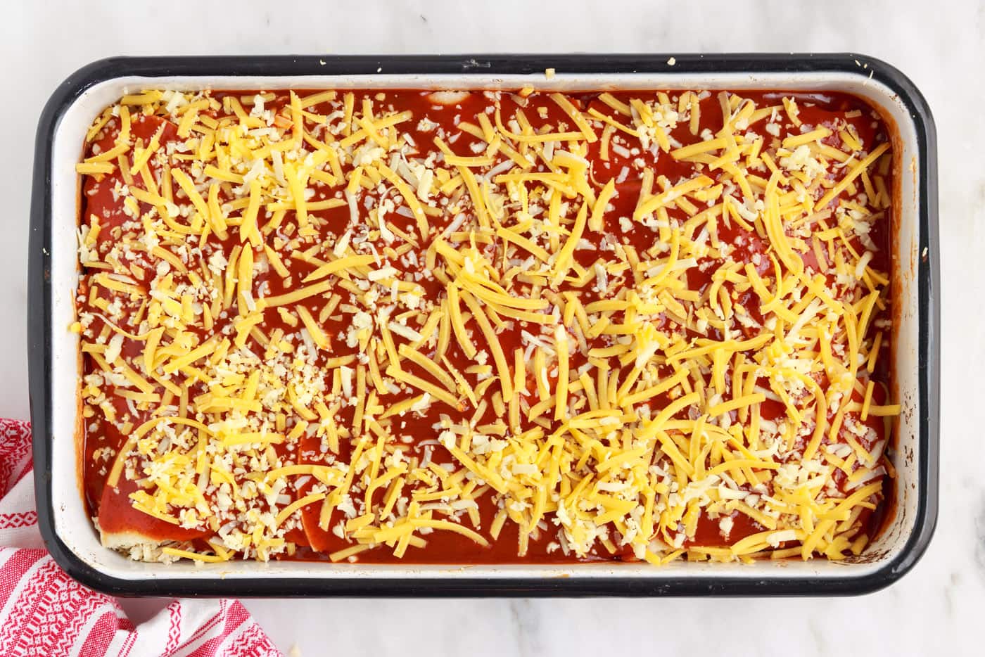 shredded cheese on top of chicken enchilada casserole