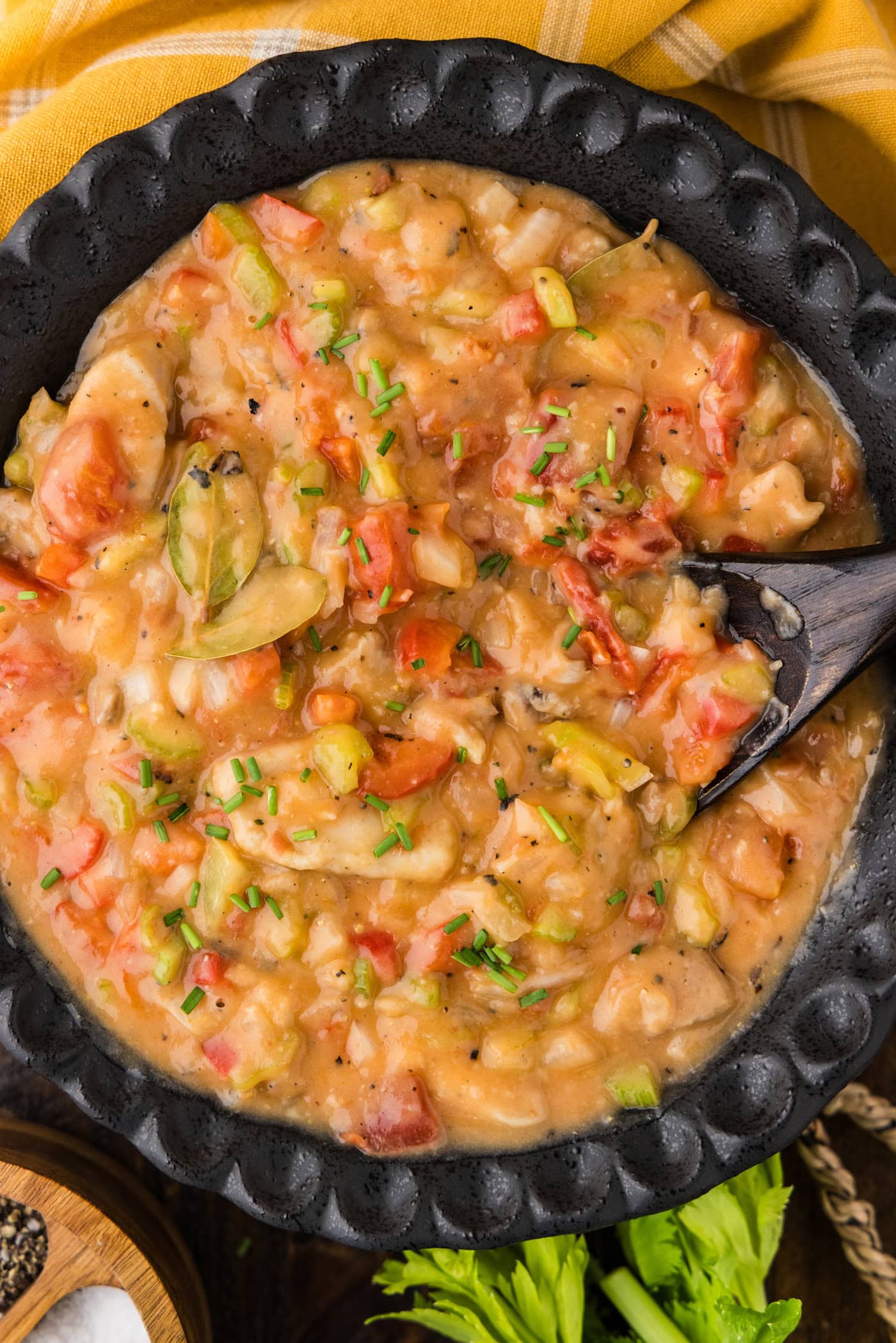Close up photo of a bowl of Chicken Etouffee with a spoon in it