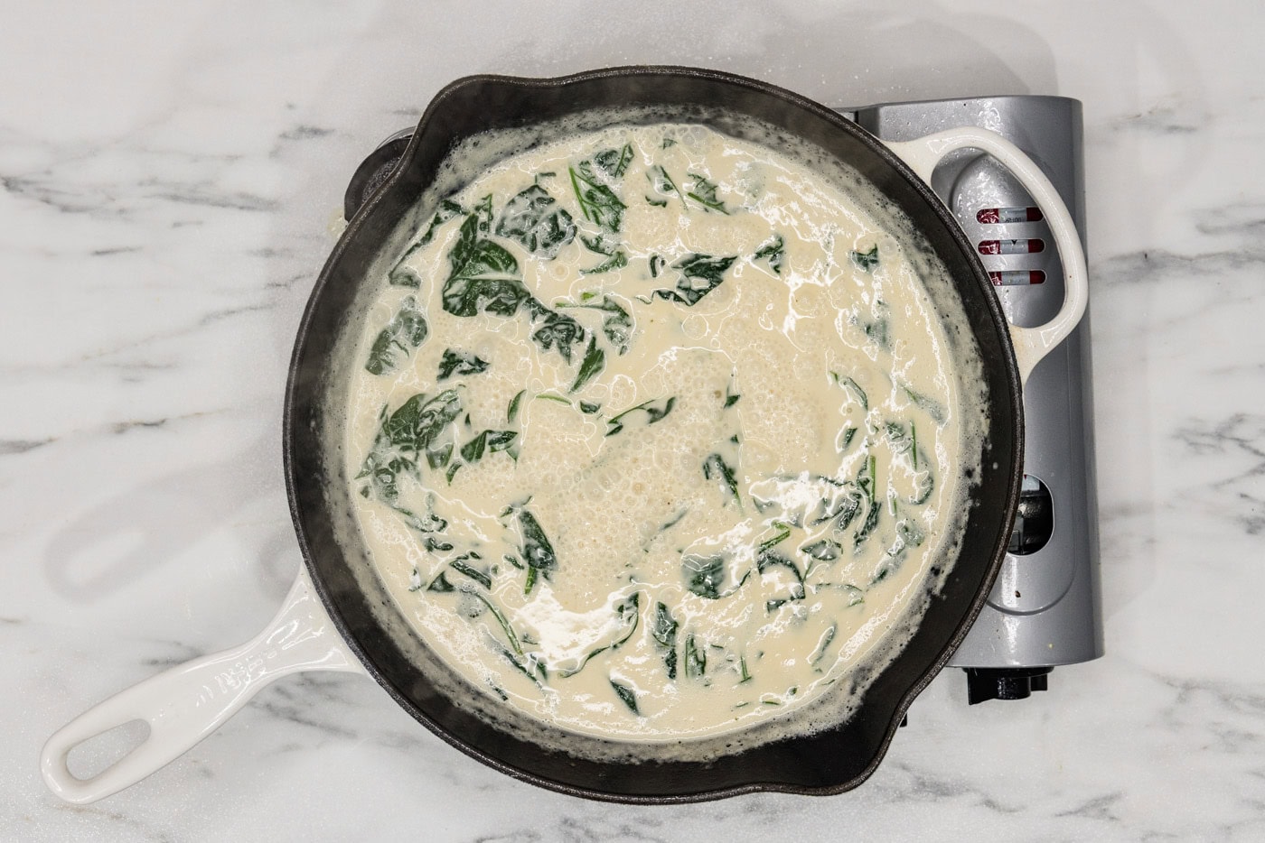 spinach in a skillet with cream sauce