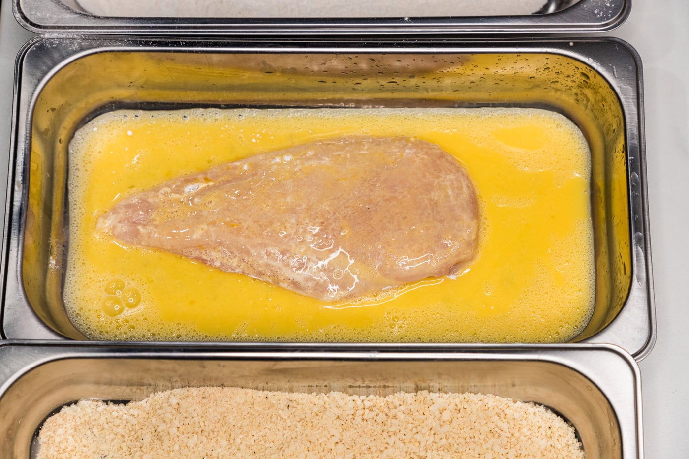 dredging chicken breast in egg