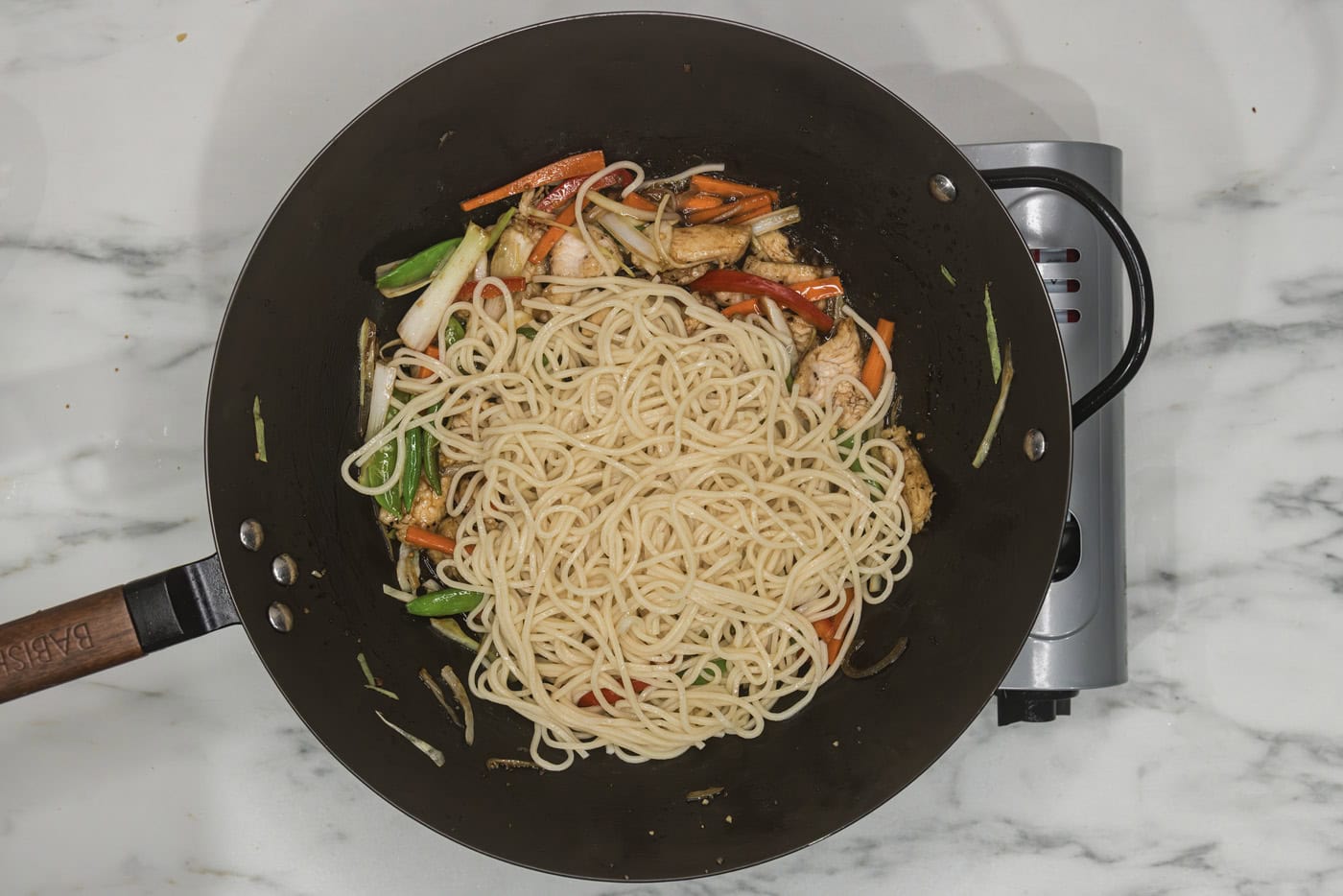 lo mein noodles added to skillet with vegetables and chicken