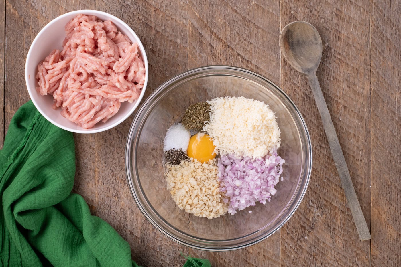 ground chicken in a bowl next to meatball ingredients