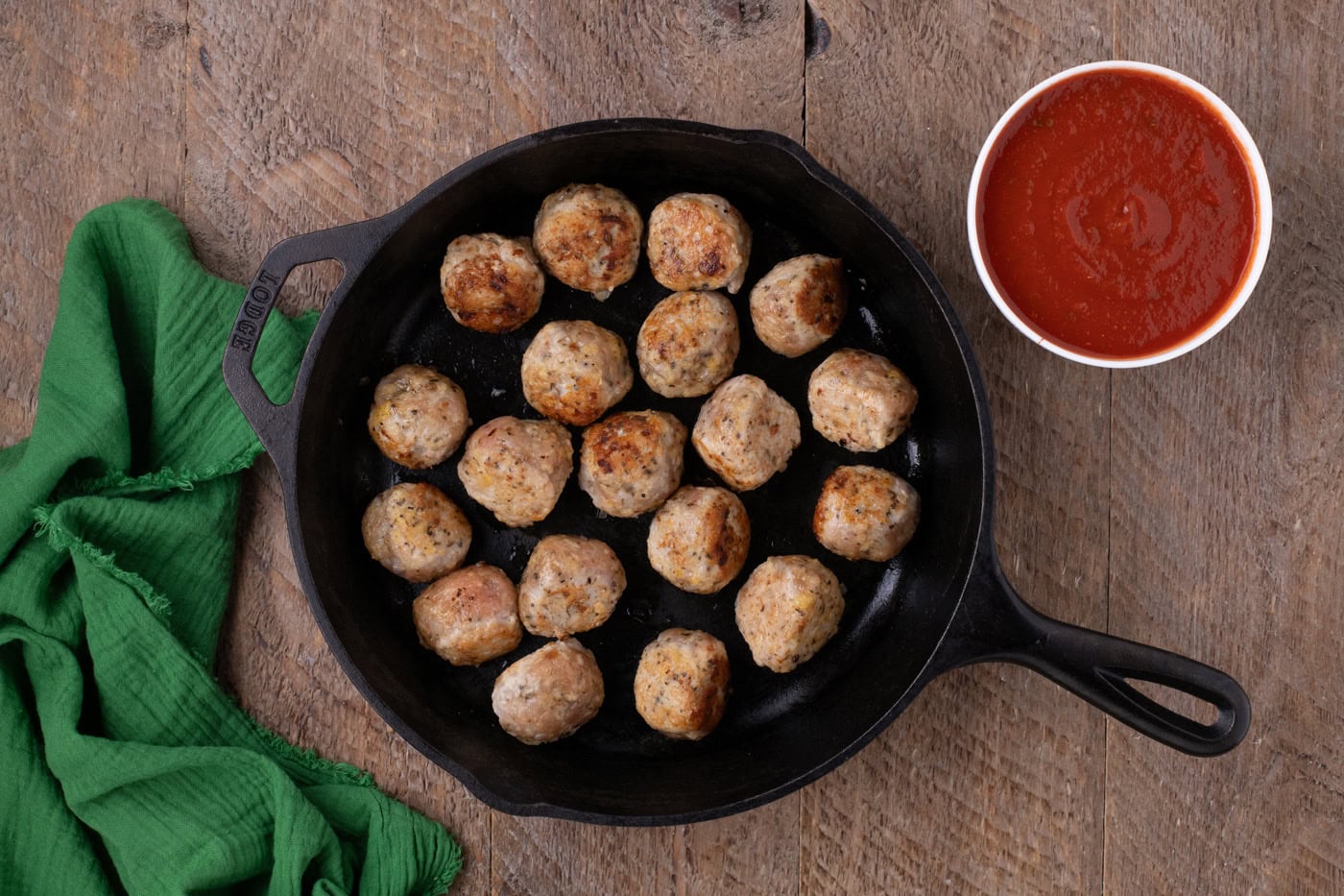 chicken meatballs browned in a cast iron skillet