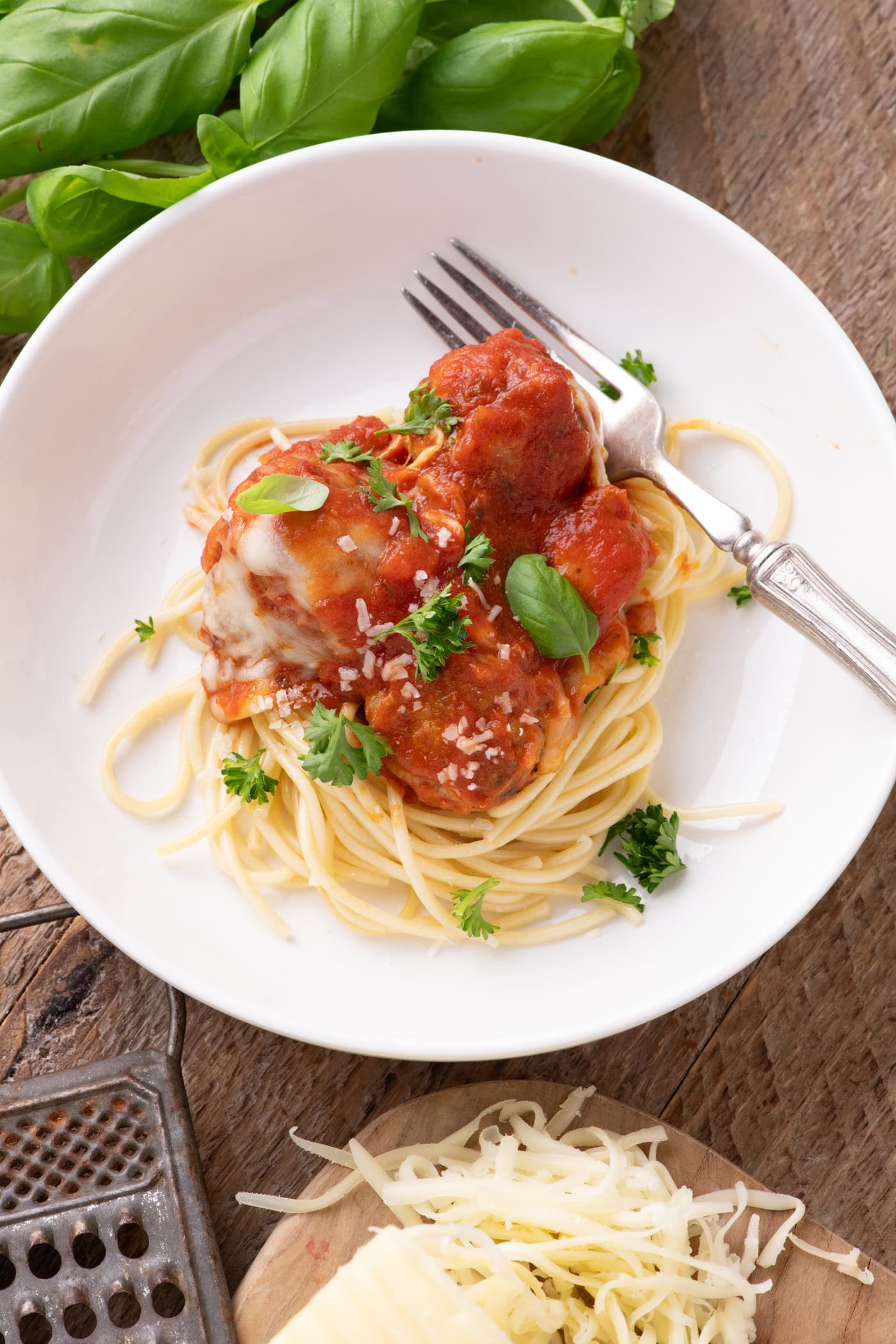 Chicken Parmesan Meatballs plated over spaghetti