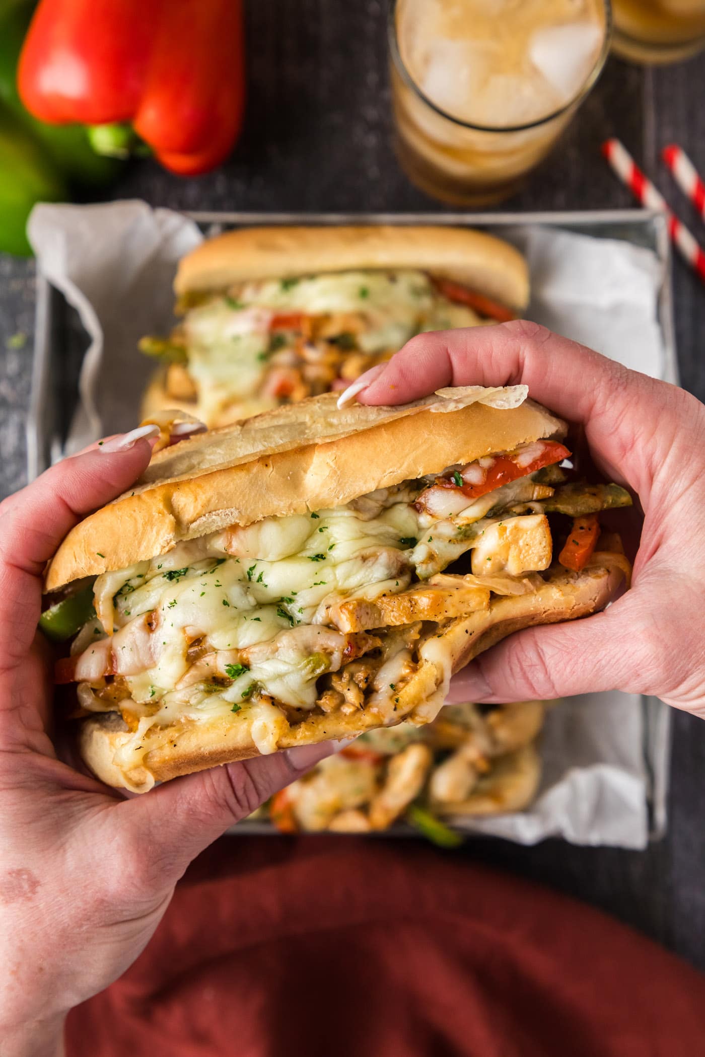 Hands holding a Chicken Philly Cheesesteak