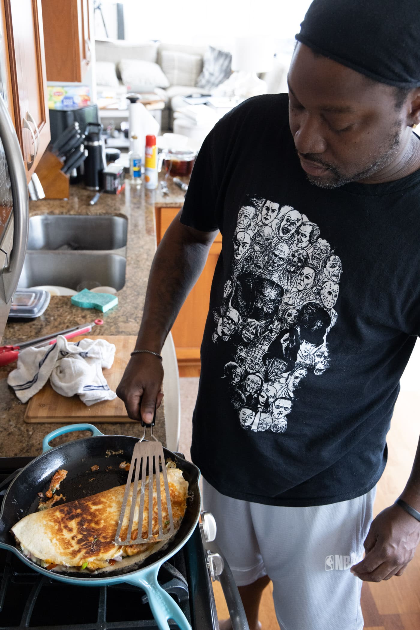 man flipping chicken quesadilla in a skillet