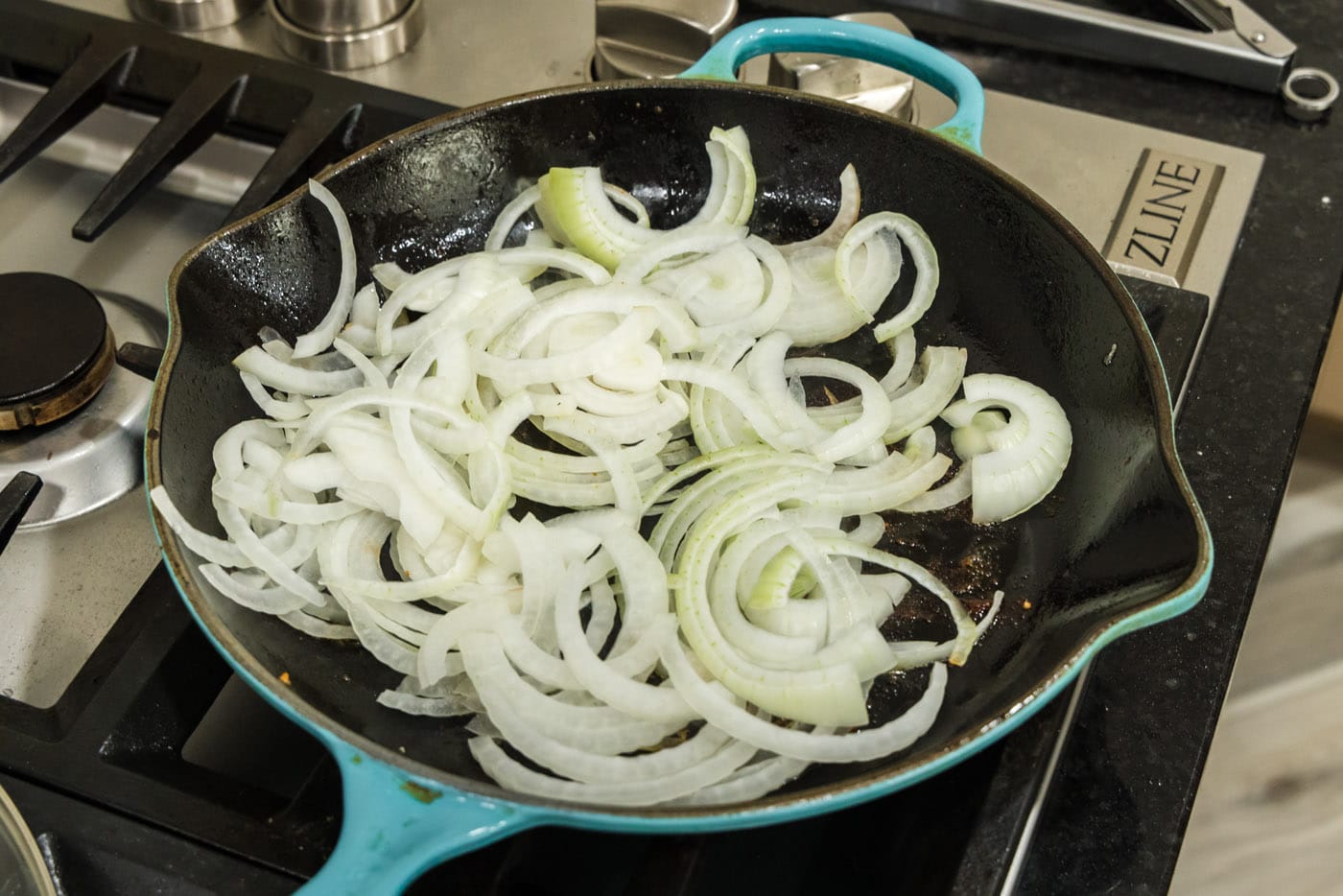 raw sliced onion in a skillet