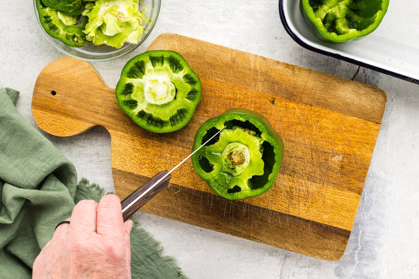 knife cutting membrane out of green bell pepper