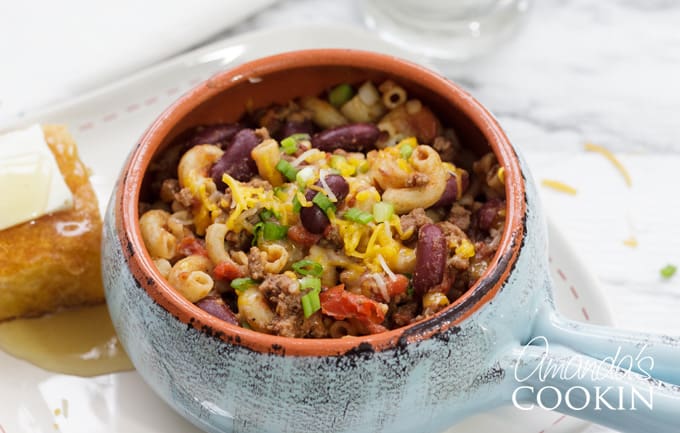 bowl of chili mac with cornbread and honey
