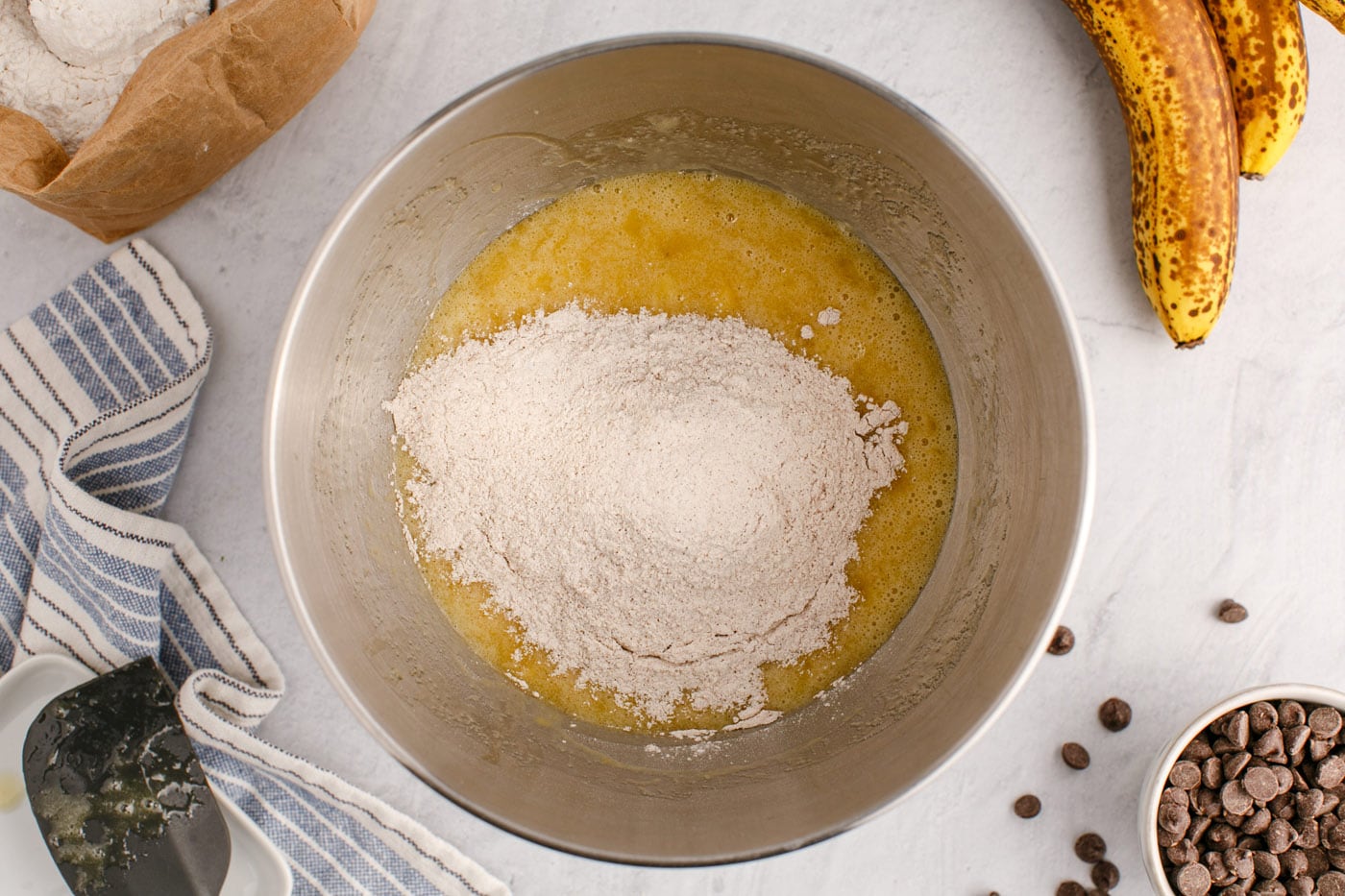 adding dry ingredients to wet ingredients for banana bread