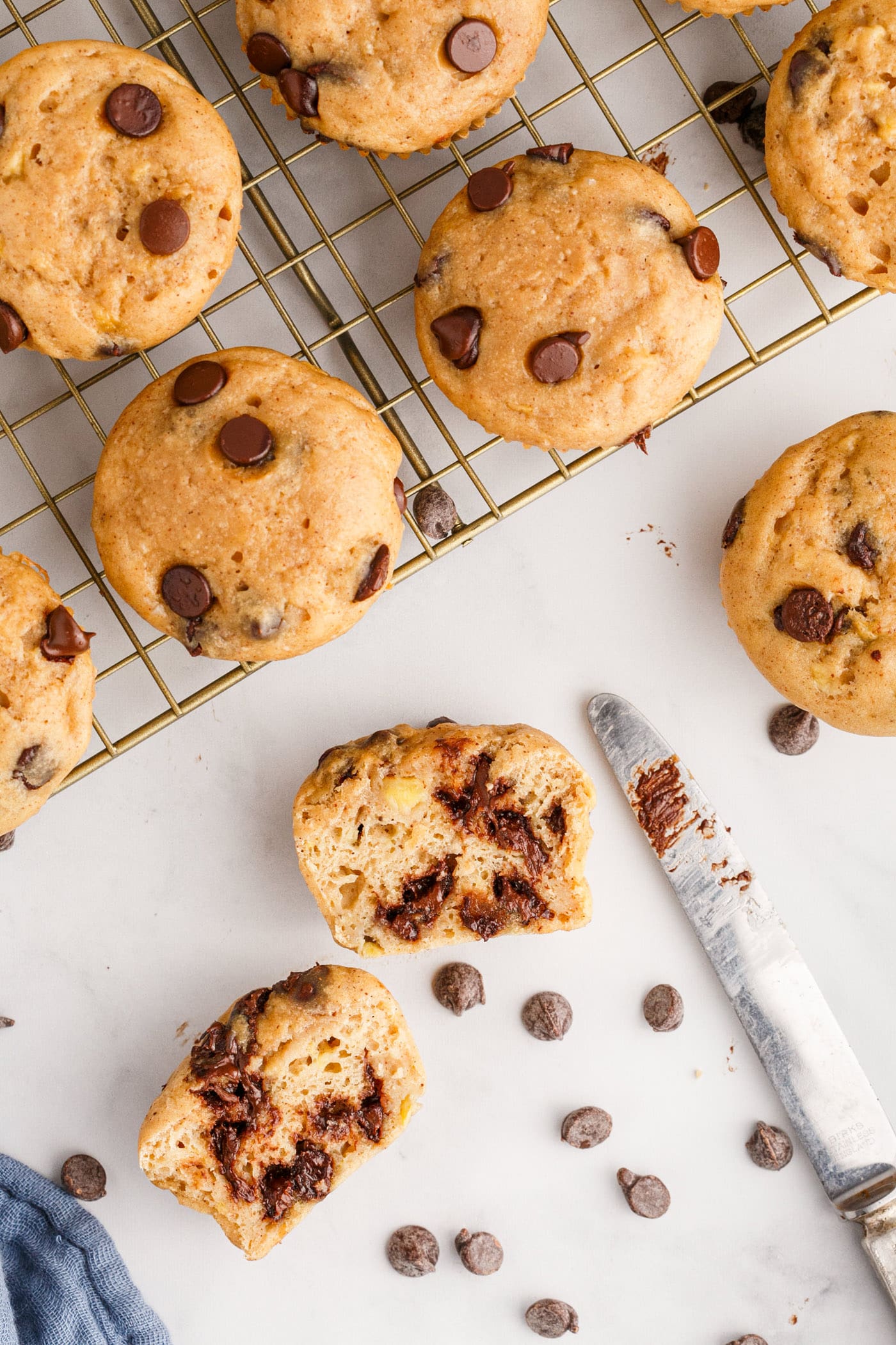 Chocolate Chip Banana Muffins on a wire rack with one cut open